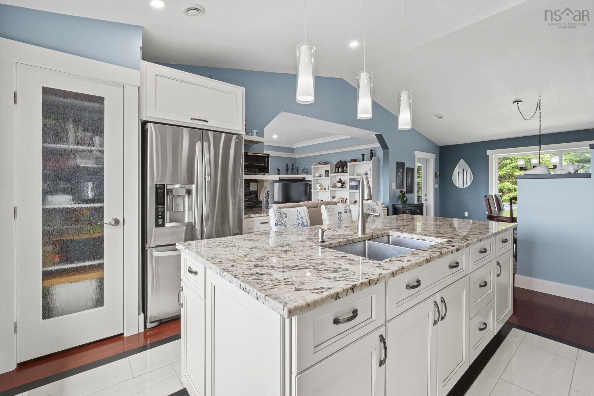 116 Whitecap Ridge, Black Point, NS (MLS® 202618413) — Kitchen island featuring a dual-basin stainless steel sink, a gooseneck faucet, and a light-toned patterned countertop