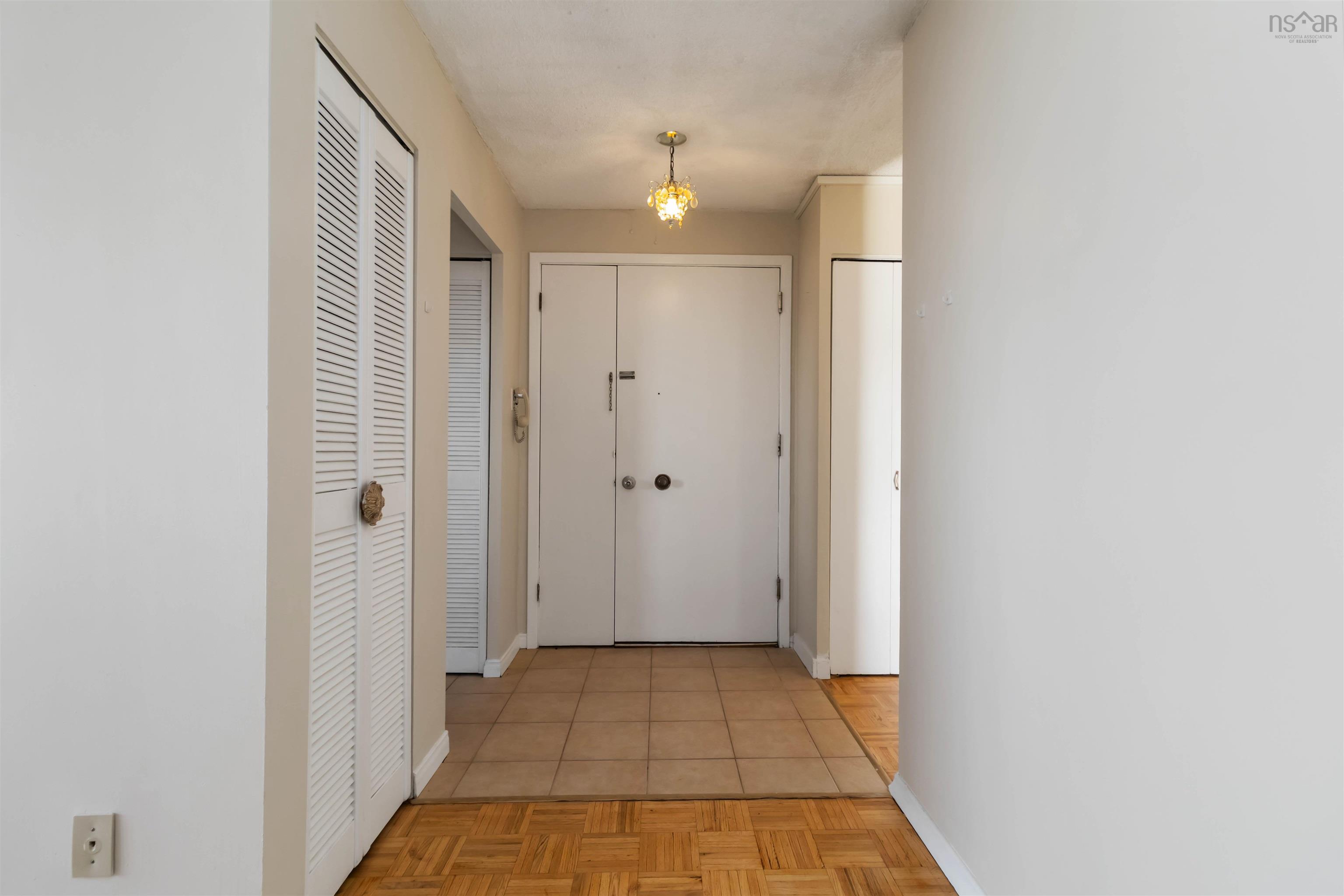 1601 5959 Spring Garden Road, Halifax, NS (MLS® 202620845) — Entryway featuring tile flooring, wood-finish flooring, and a flush-mount light fixture