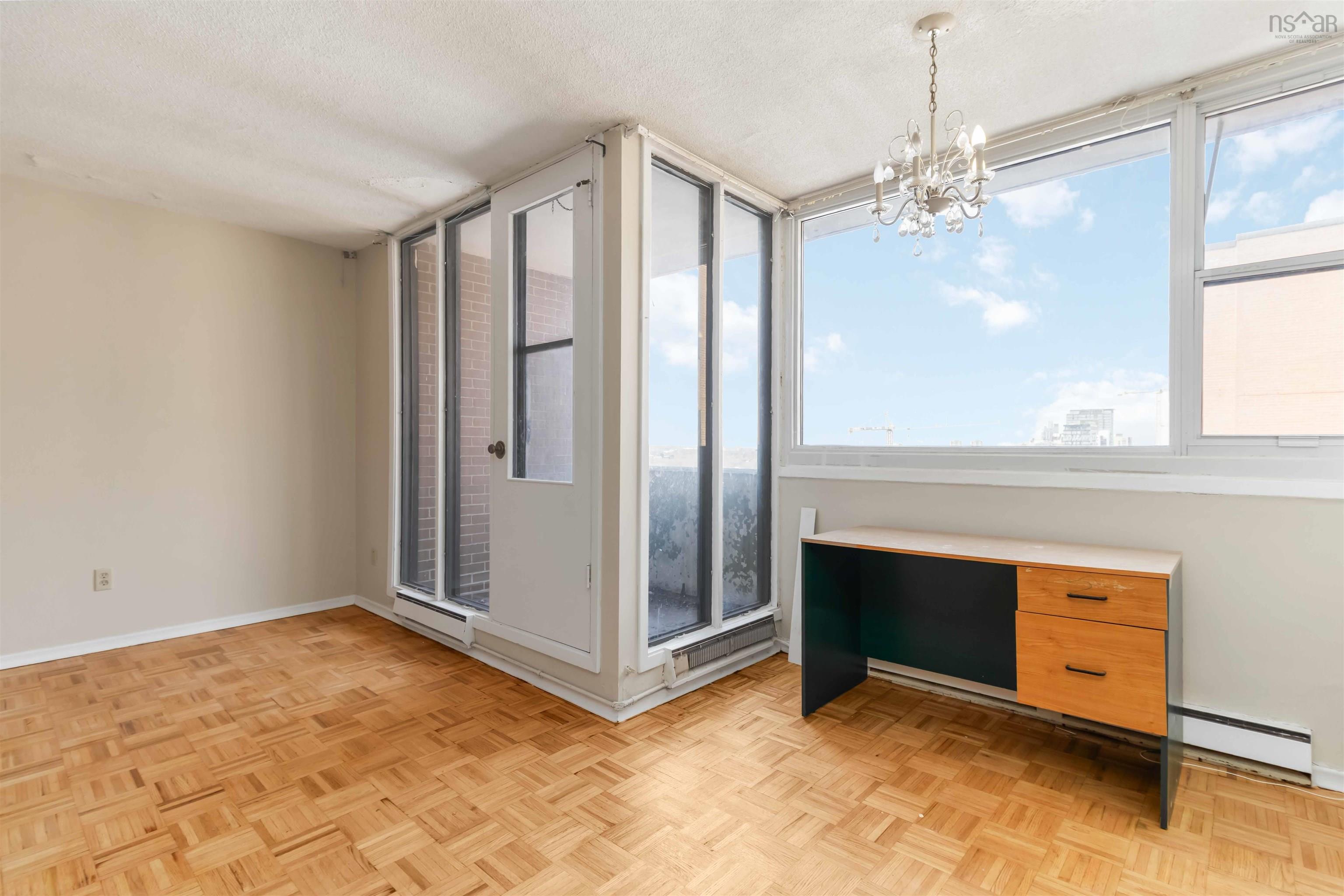 1601 5959 Spring Garden Road, Halifax, NS (MLS® 202620845) — Parquet wood-finish flooring, full-height windows, a glass-paneled door, and a multi-arm chandelier