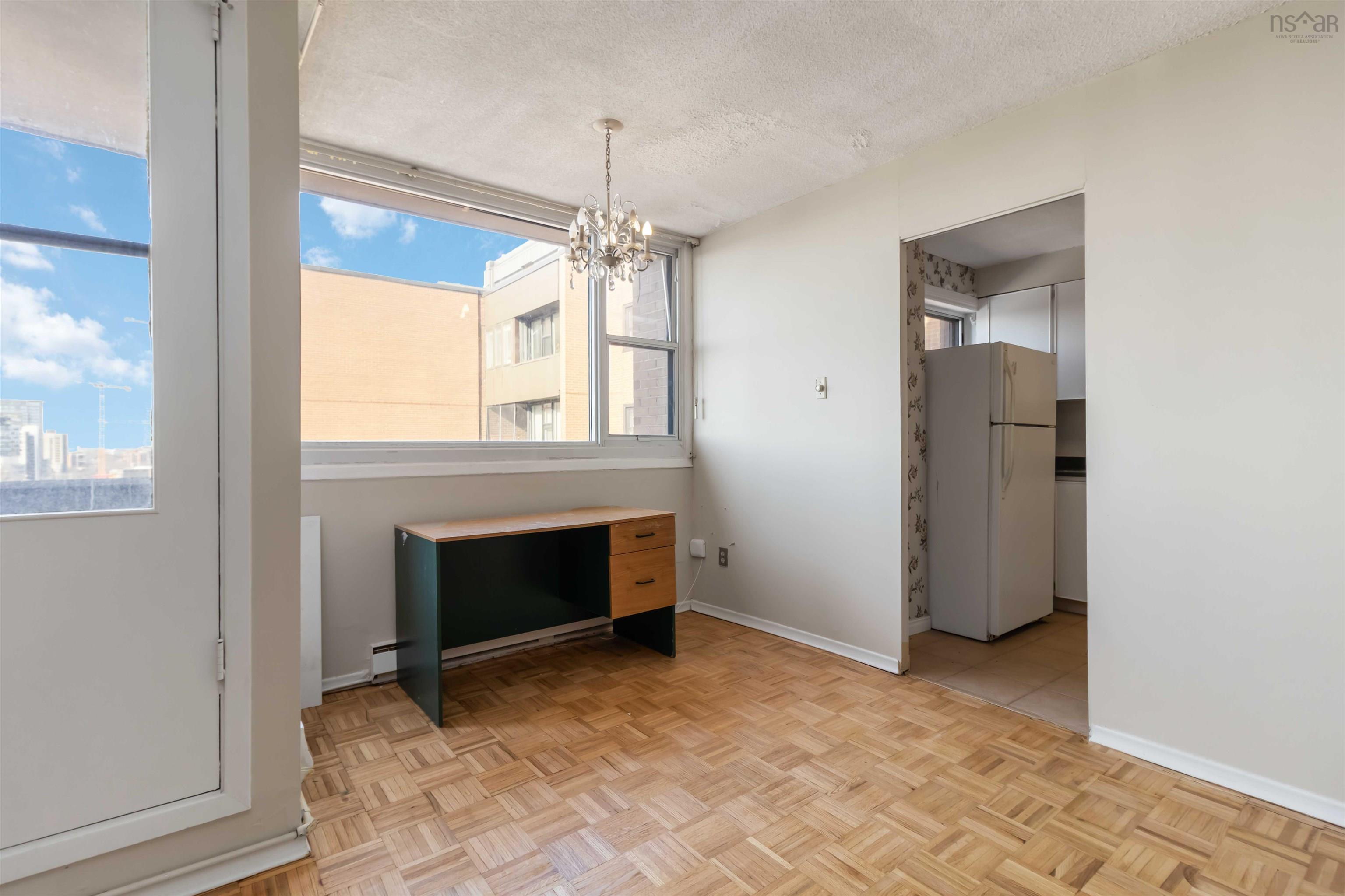 1601 5959 Spring Garden Road, Halifax, NS (MLS® 202620845) — Parquet wood-finish flooring, large window, white walls, and a crystal chandelier
