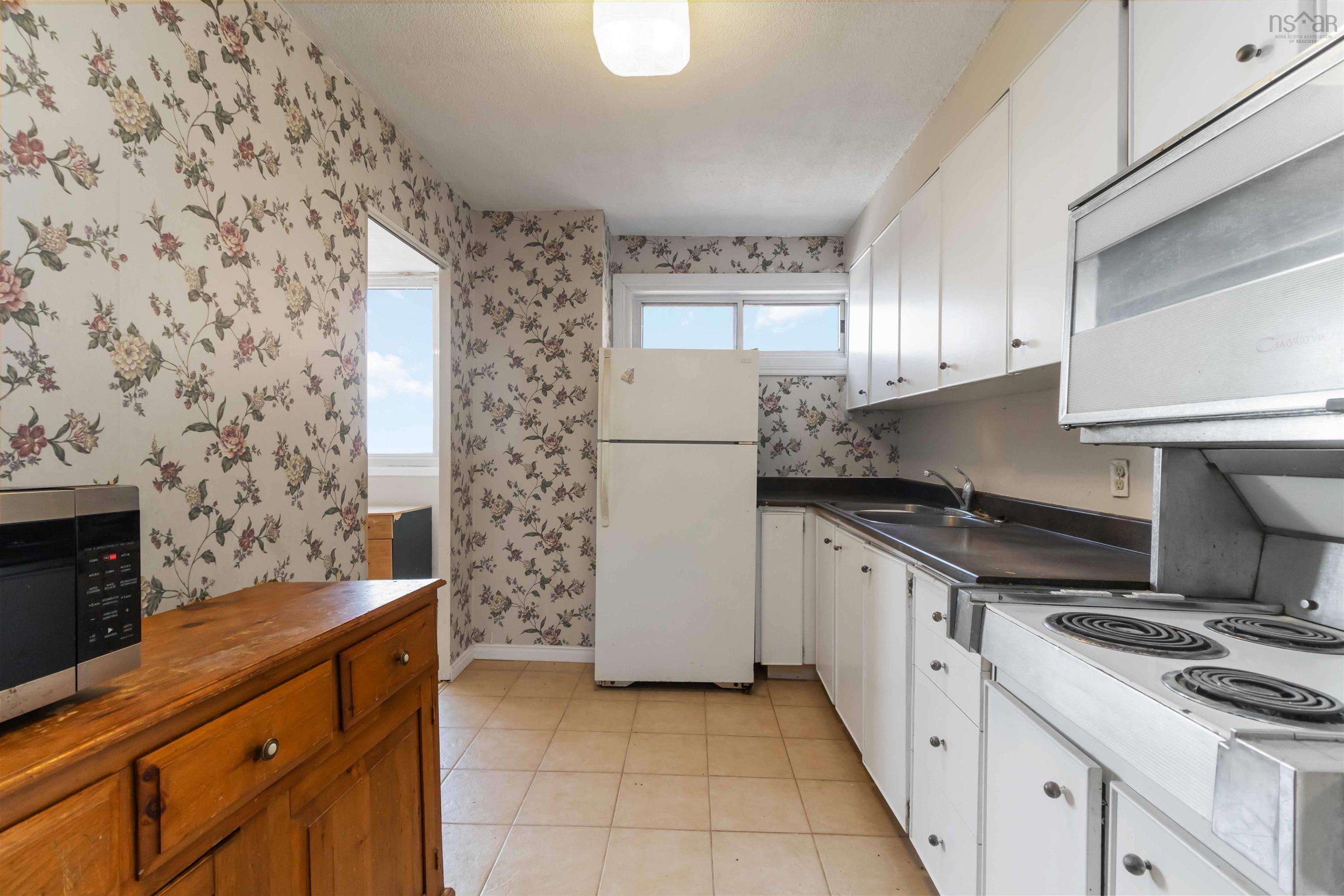 1601 5959 Spring Garden Road, Halifax, NS (MLS® 202620845) — Galley kitchen featuring white cabinetry, a built-in electric range, and a dual-basin sink