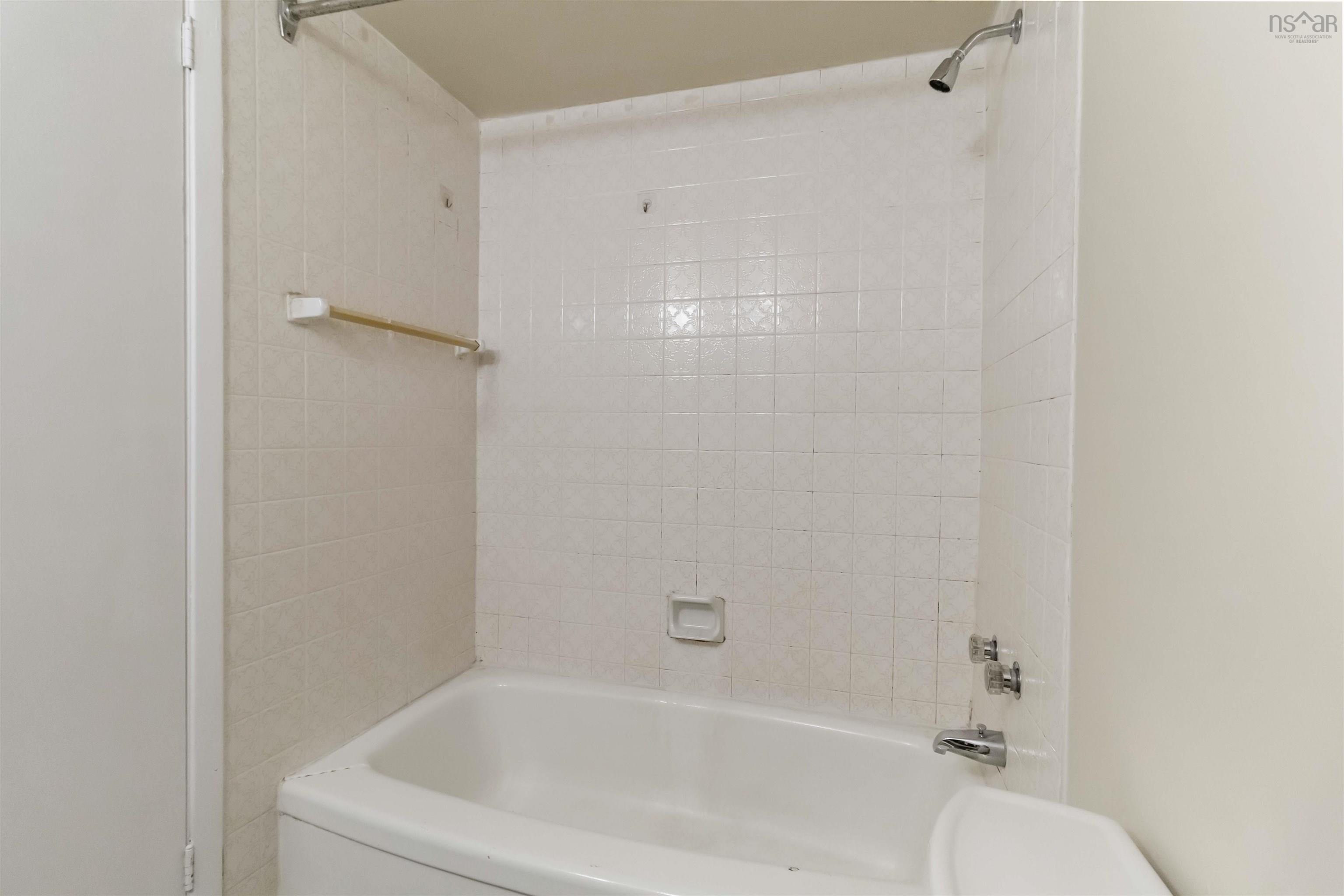 1601 5959 Spring Garden Road, Halifax, NS (MLS® 202620845) — White tile tub surround with integrated soap dish and chrome fixtures