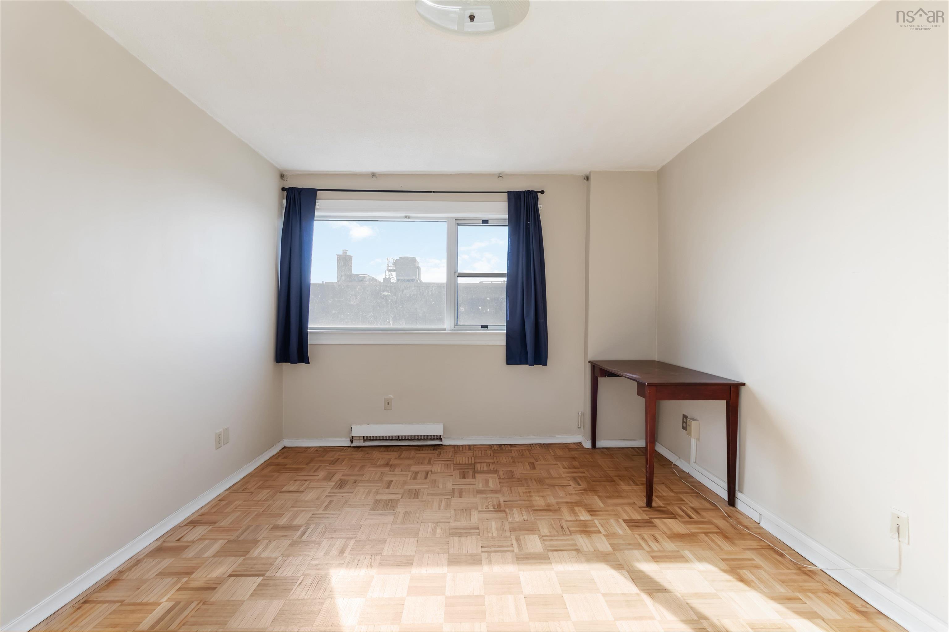 1601 5959 Spring Garden Road, Halifax, NS (MLS® 202620845) — Hardwood parquet flooring, neutral wall tones, and a large window with a cityscape backdrop