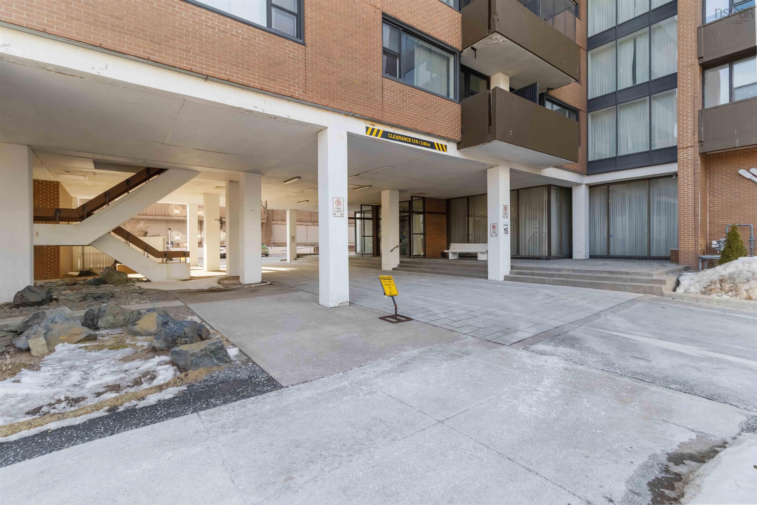 1601 5959 Spring Garden Road, Halifax, NS (MLS® 202620845) — Brick exterior building with multiple balconies, covered entrance, and concrete pathways