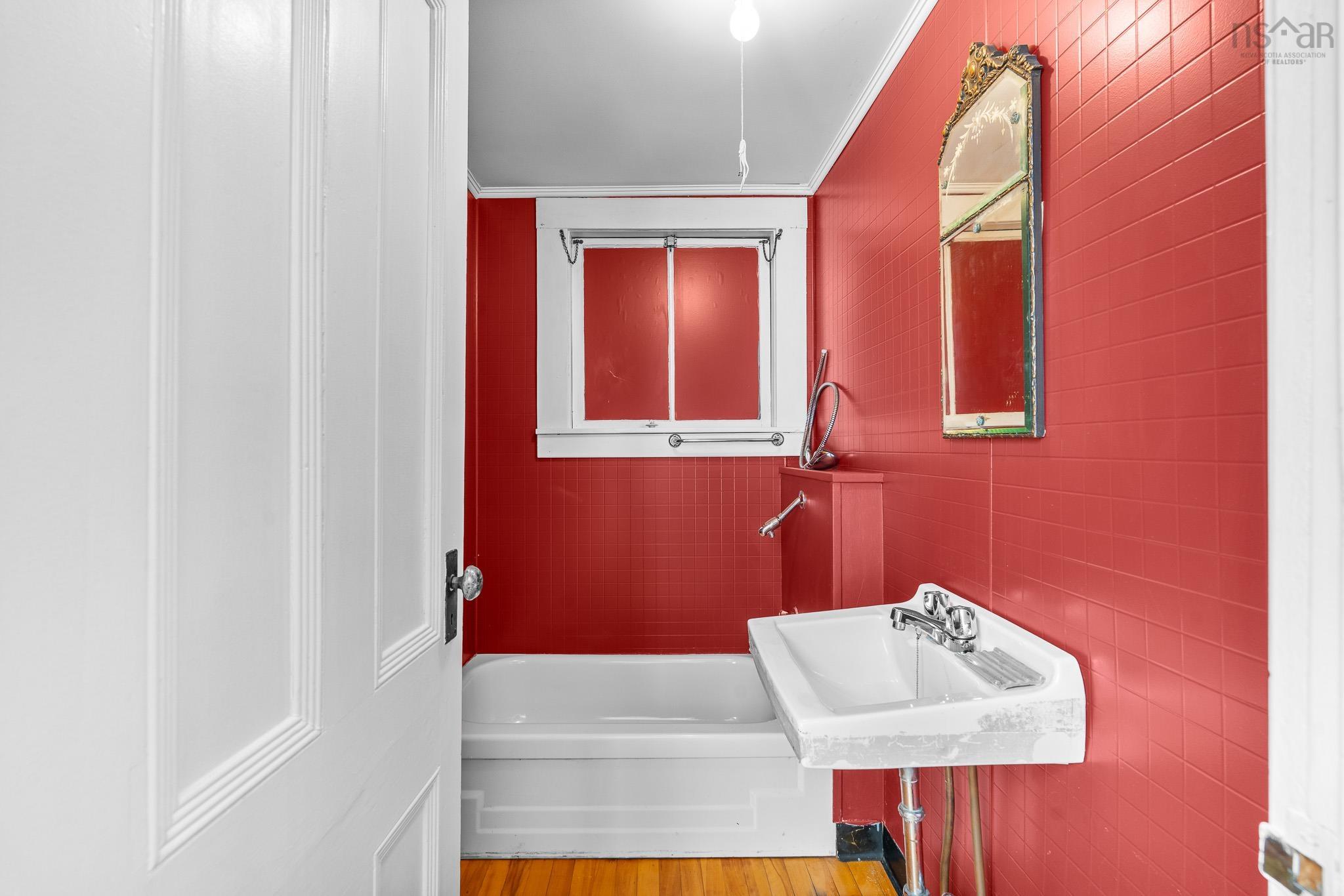 28 Arlington Place, Truro, NS (MLS® 202623012) — This unique bathing room, featuring a bathtub and sink, likely dates back to when the home was configured as two separate living units. A separate half bath is conveniently located just around the corner.