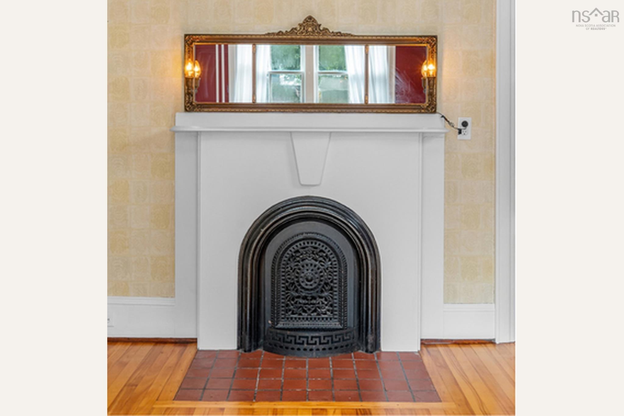 28 Arlington Place, Truro, NS (MLS® 202623012) — A beautiful nod to the home's history, this decorative fireplace features an ornate cast-iron insert, classic mantel and elegant antique-style mirror, adding timeless character and charm to the dining room. (Fireplace is non-operational.)
