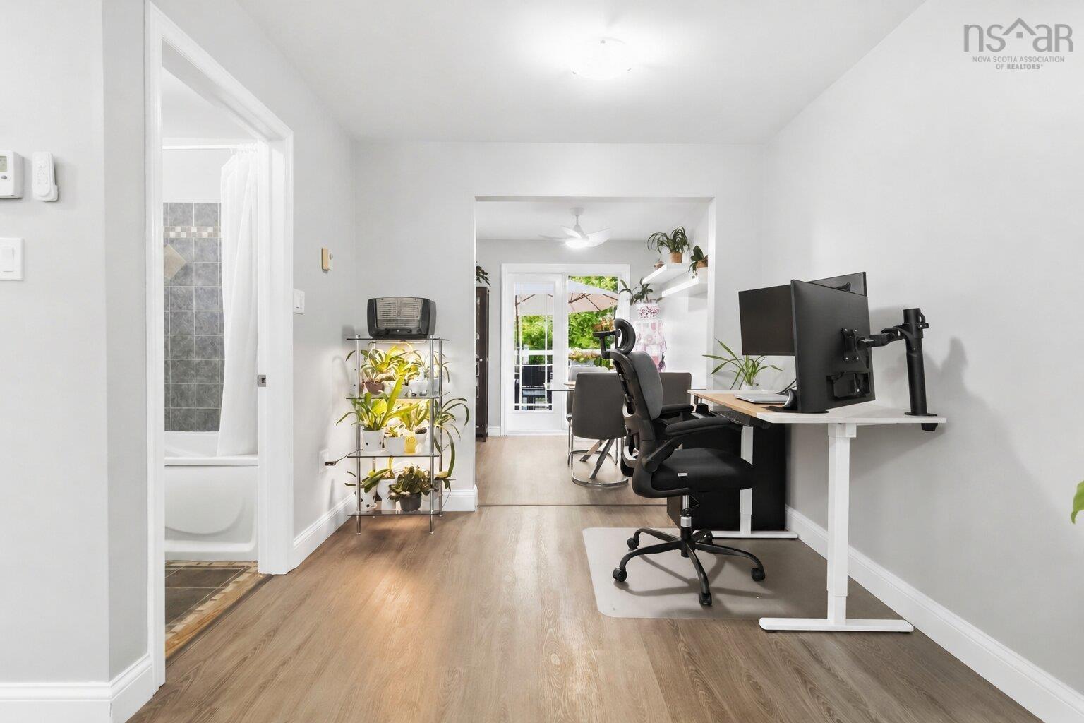 34 Lindsay Court, Lower Sackville, NS (MLS® 202624063) — Wood-finish flooring throughout, bright interior with white walls, and a visible bathroom featuring tiled walls and a white bathtub