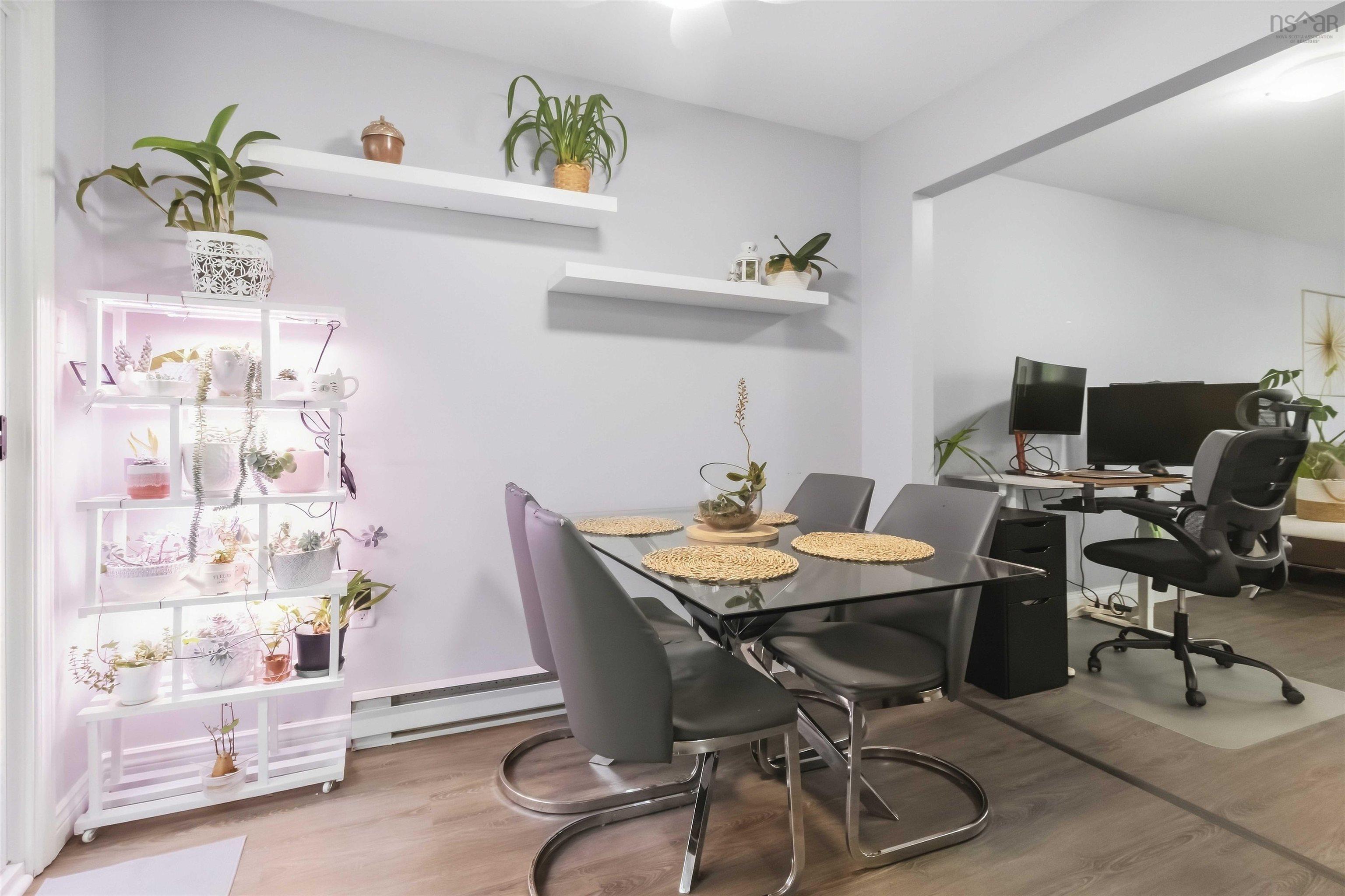 34 Lindsay Court, Lower Sackville, NS (MLS® 202624063) — Dining area featuring wood-finish flooring, a glass-top table with a chrome base, and an open doorway to an adjoining space