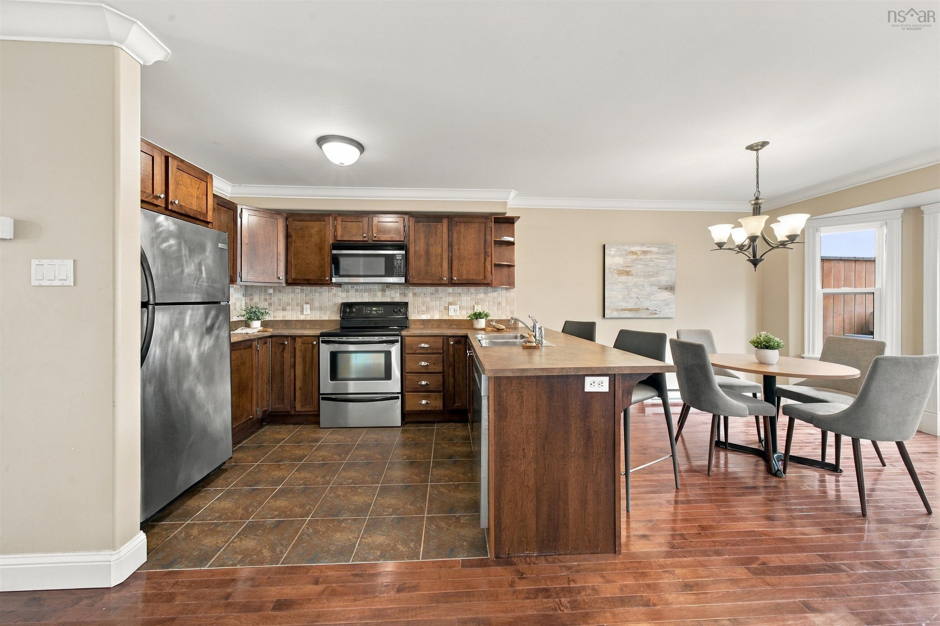 150 Transom Drive, Halifax, NS (MLS® 202625460) — Kitchen with wood cabinetry, stainless steel appliances, tile flooring, and a breakfast bar