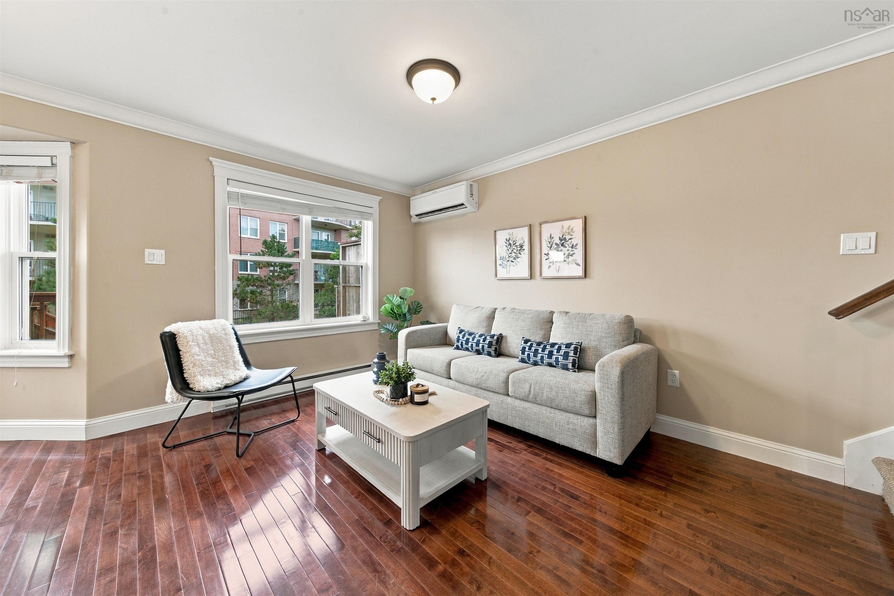 150 Transom Drive, Halifax, NS (MLS® 202625460) — Rich wood-finish flooring with crisp white trim, multiple windows, wall-mounted climate control unit, and a flush-mount ceiling light fixture