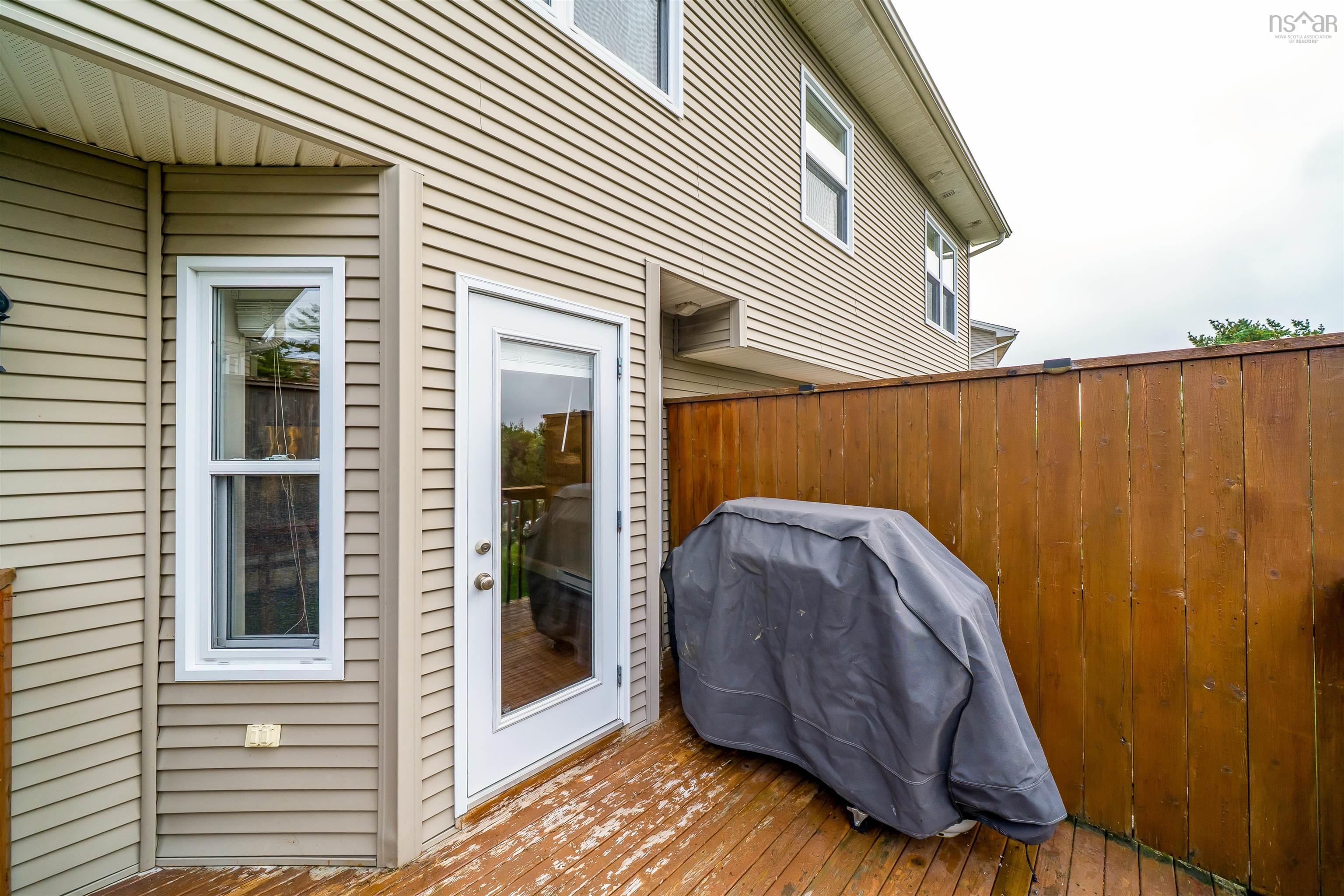 150 Transom Drive, Halifax, NS (MLS® 202625460) — Outdoor deck space featuring a full-light panel door and a vertical window, complete with exterior siding and a wooden privacy fence