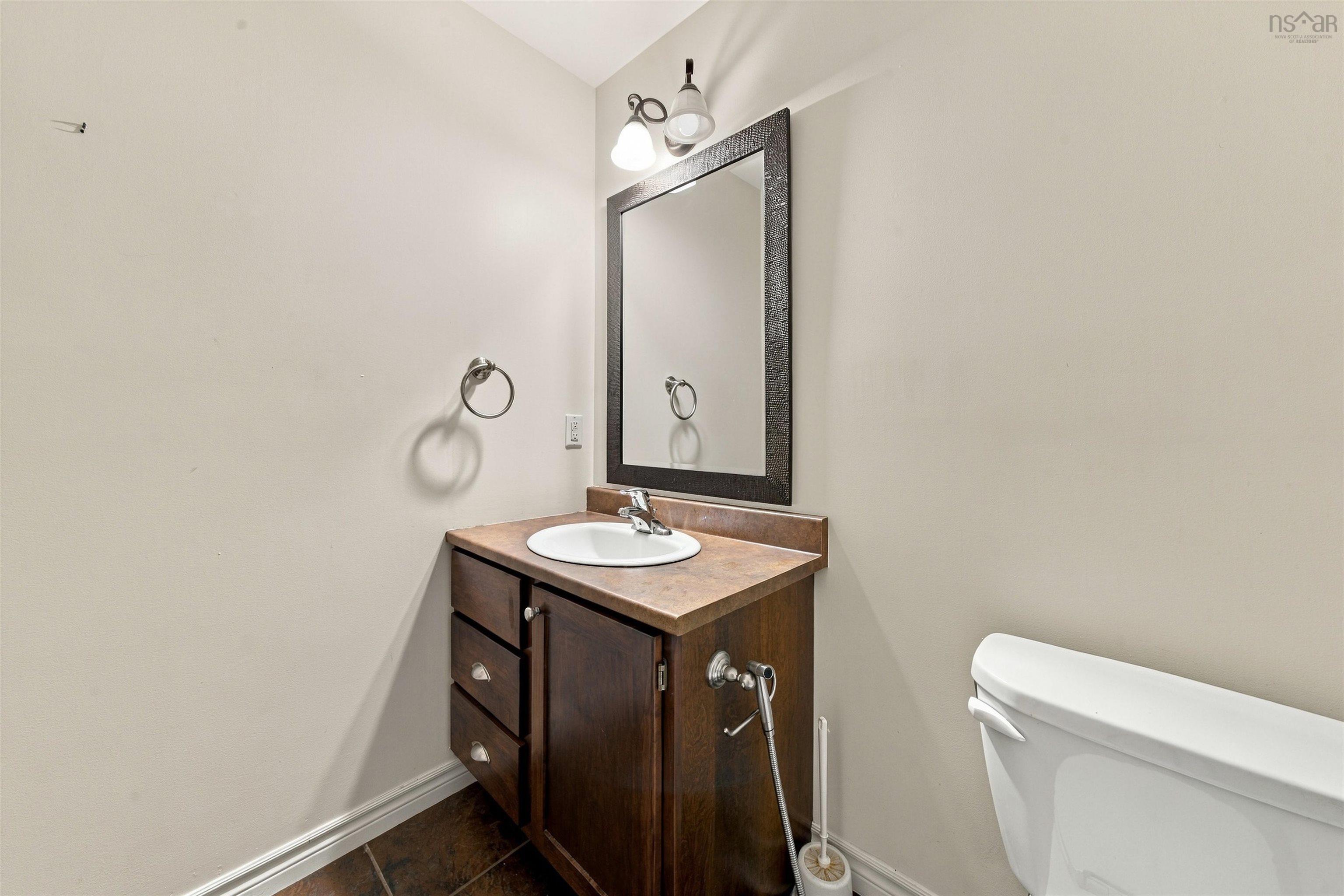 150 Transom Drive, Halifax, NS (MLS® 202625460) — Dark wood-finish vanity with an integrated sink, polished chrome faucet, and a framed mirror