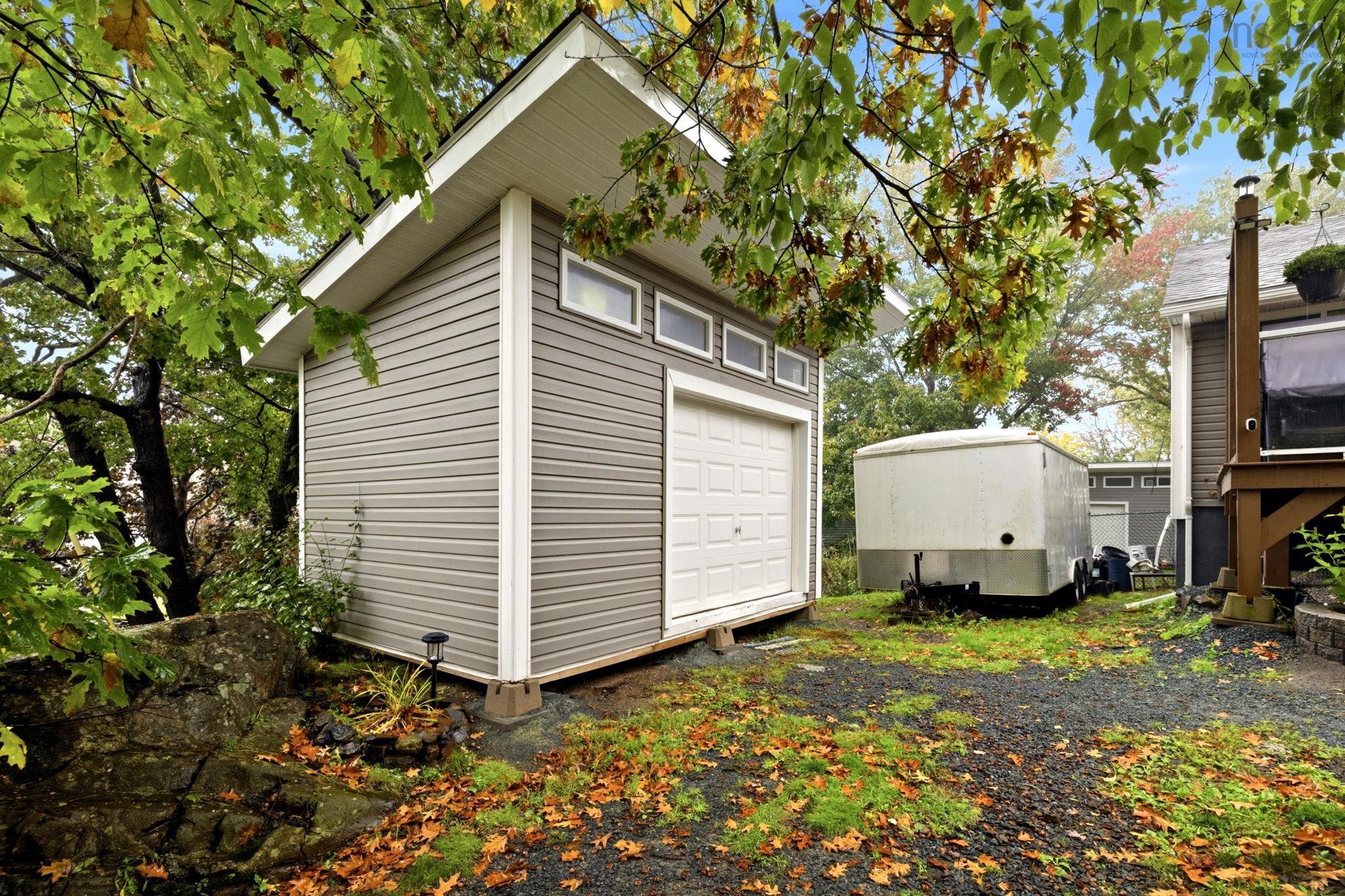 25 Circle Drive, Halifax, NS (MLS® 202625881) — Detached outbuilding featuring horizontal lap siding, a shed-style roof, high-set transom windows, and a white roll-up garage door