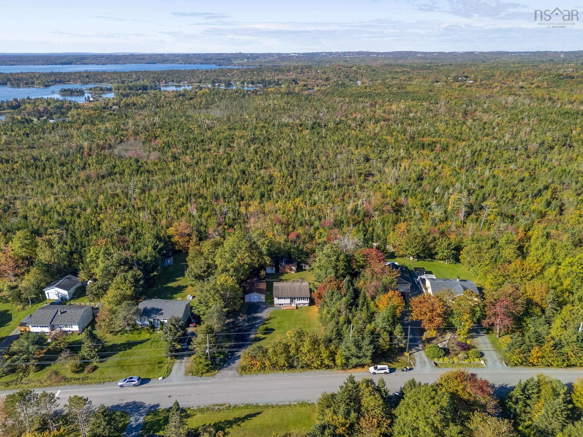 128 Doherty Drive, Lawrencetown, NS (MLS® 202625891) — Aerial perspective of a multi-acre wooded landscape featuring expansive forest cover, mature deciduous and coniferous trees, and regional water frontage