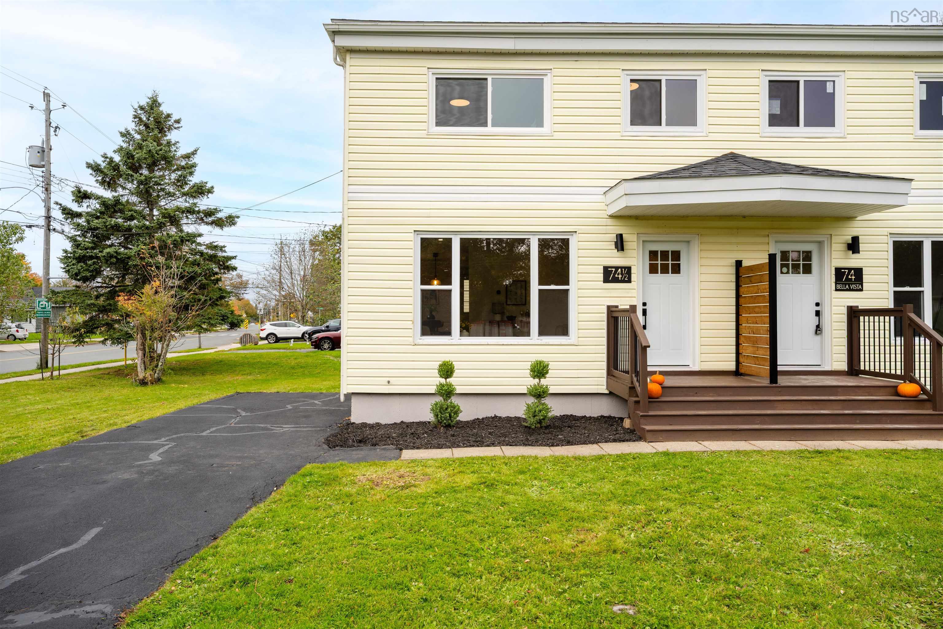 74 1/2 Belle Vista Drive, Dartmouth, NS (MLS® 202625912) — Multi-family exterior featuring horizontal siding, asphalt driveway, front entry porches with wood-tone stairs, and tiered evergreen shrubbery