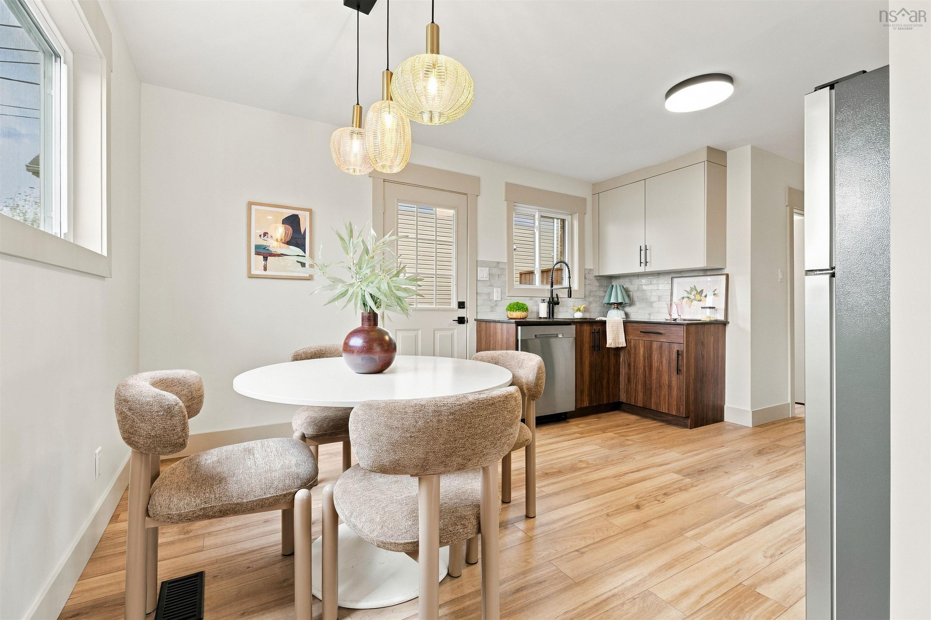 74 1/2 Belle Vista Drive, Dartmouth, NS (MLS® 202625912) — Kitchen featuring two-tone cabinetry, wood-finish flooring, a stainless steel dishwasher, a dark-finish faucet, and three glass pendant lights