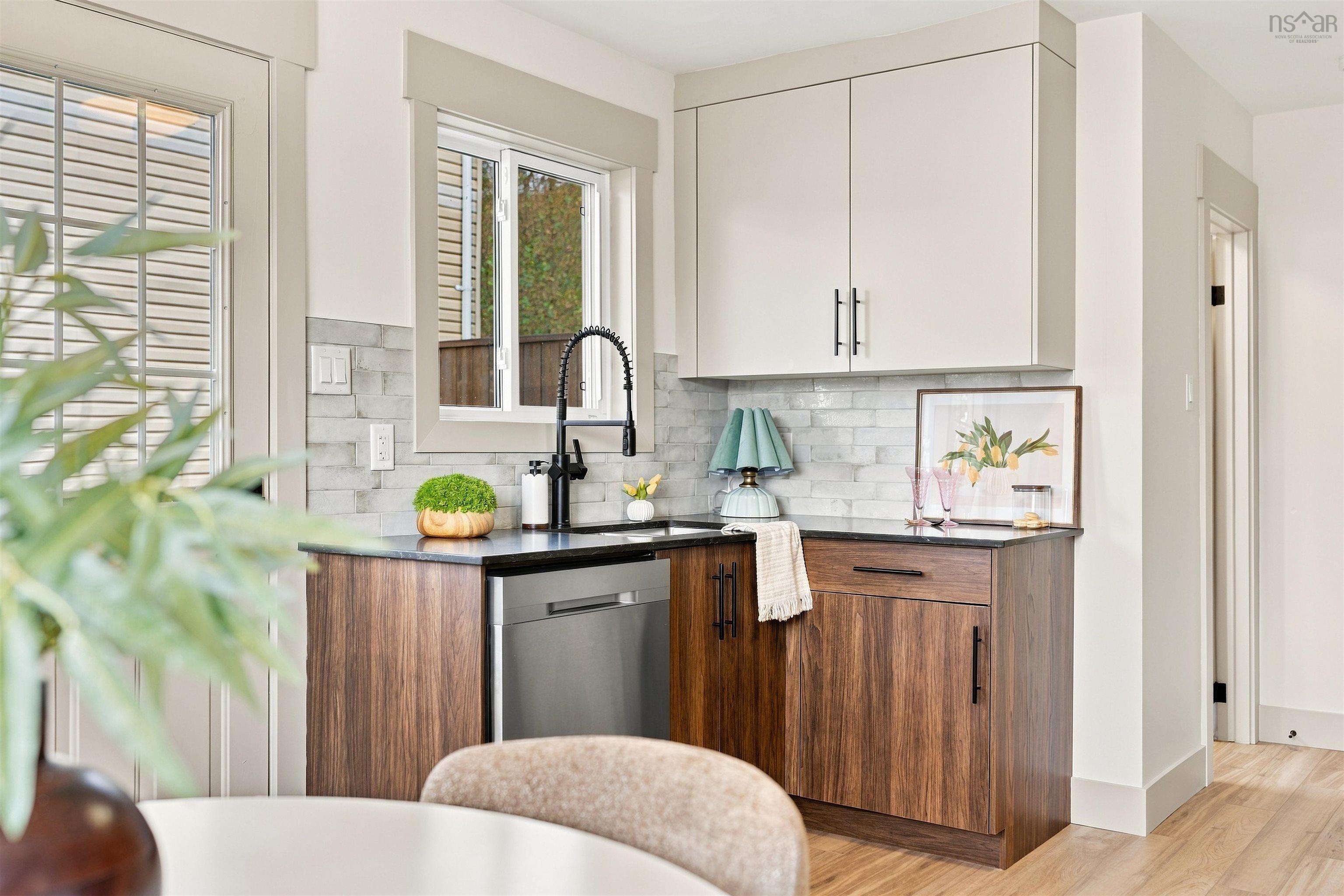74 1/2 Belle Vista Drive, Dartmouth, NS (MLS® 202625912) — Kitchen area featuring wood-finish lower cabinetry, solid-surface countertops, subway tile backsplash, stainless steel dishwasher, and matte black pull-down faucet