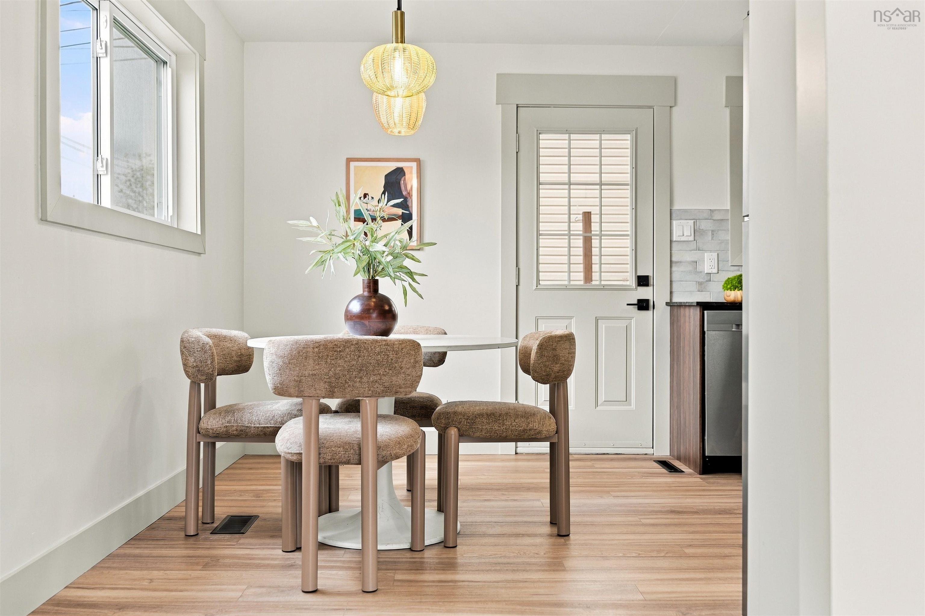 74 1/2 Belle Vista Drive, Dartmouth, NS (MLS® 202625912) — Eat-in space featuring wood-finish flooring, a textured glass pendant light fixture, a multi-pane glass entry door, and crisp neutral walls