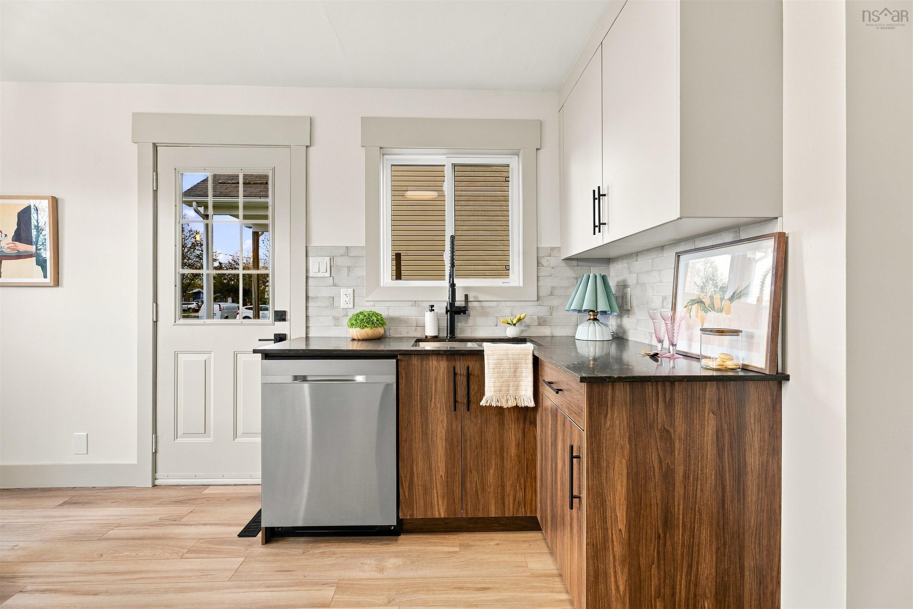 74 1/2 Belle Vista Drive, Dartmouth, NS (MLS® 202625912) — Kitchen area featuring wood-finish lower cabinetry, white upper cabinetry, stone-texture backsplash, dark countertops, and stainless steel dishwasher