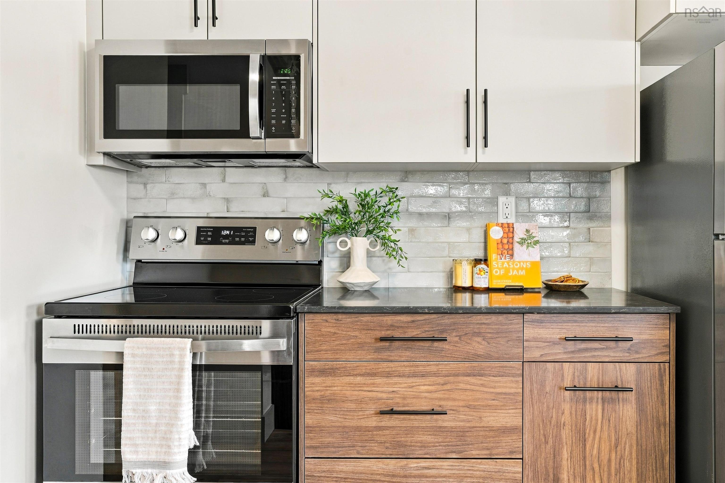 74 1/2 Belle Vista Drive, Dartmouth, NS (MLS® 202625912) — Kitchen featuring stainless steel appliances, wood-finish cabinetry, dark stone-composite countertops, and a textured subway tile backsplash