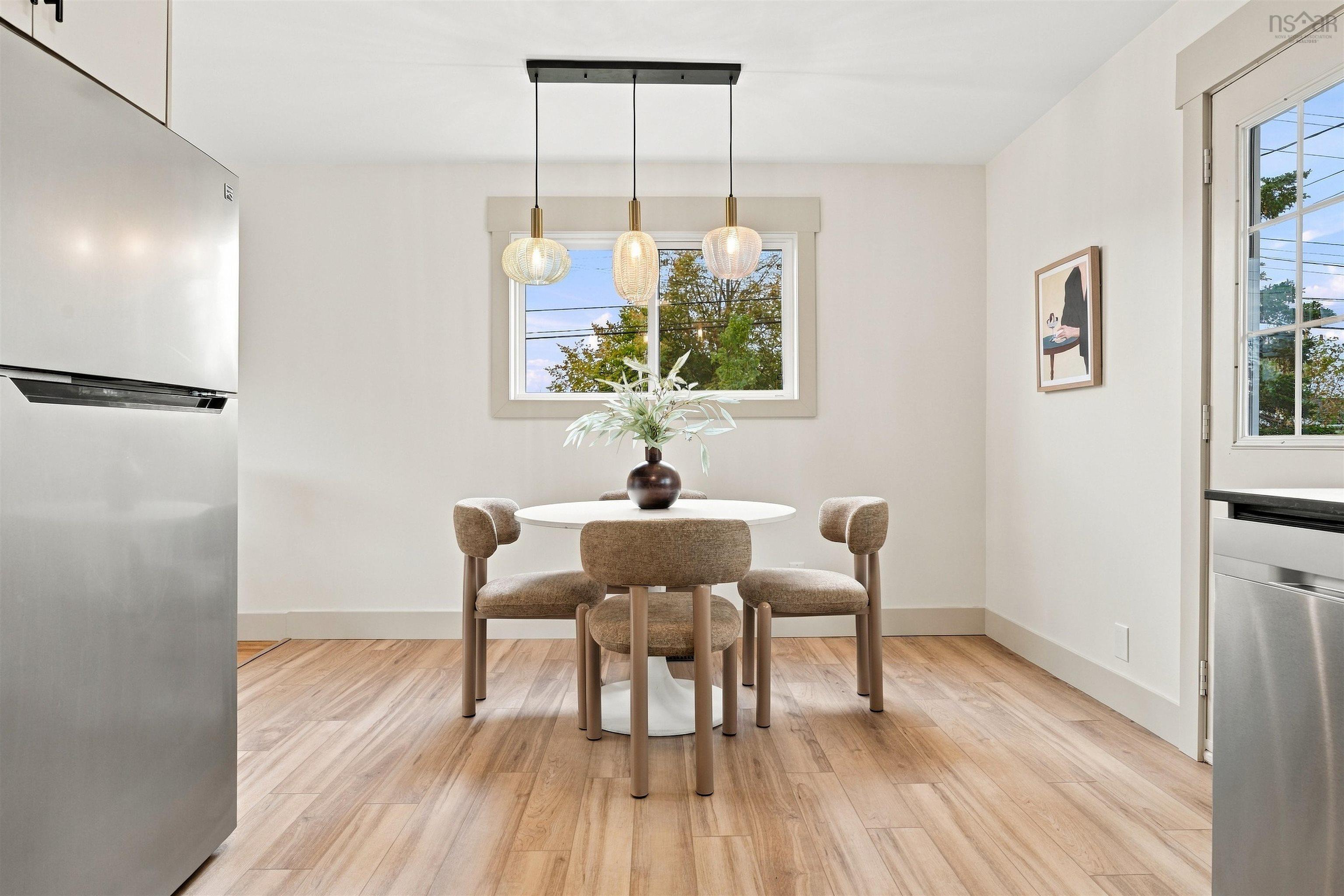 74 1/2 Belle Vista Drive, Dartmouth, NS (MLS® 202625912) — Kitchen area featuring wood-finish flooring, a three-light pendant fixture with textured glass shades, and stainless steel appliances