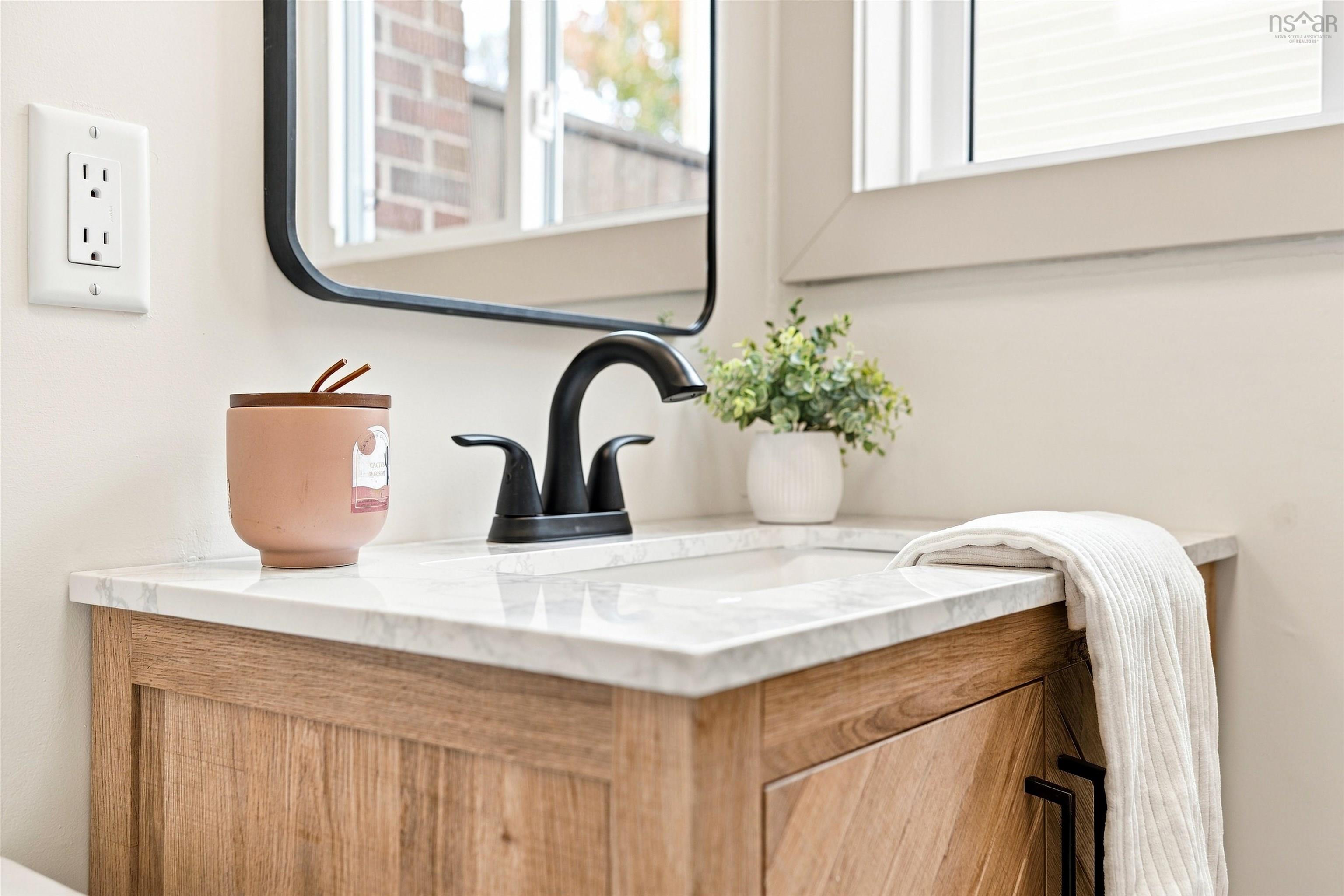 74 1/2 Belle Vista Drive, Dartmouth, NS (MLS® 202625912) — Wood-finish vanity featuring herringbone detailing, stone-composite countertop, matte black faucet, and rectangular mirror