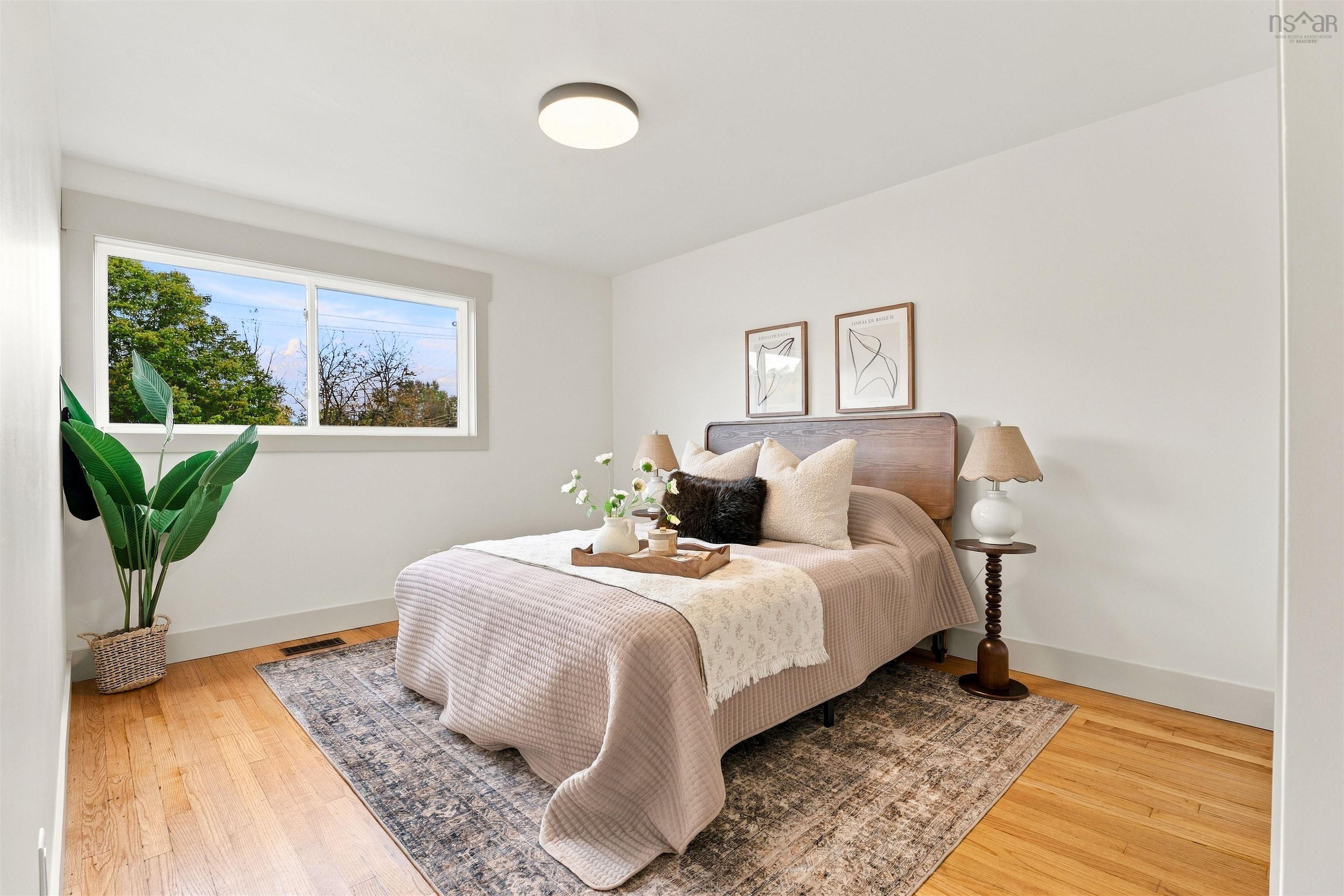 74 1/2 Belle Vista Drive, Dartmouth, NS (MLS® 202625912) — Room featuring wood-finish flooring, a neutral color palette, a sliding window, and a circular flush-mount ceiling light