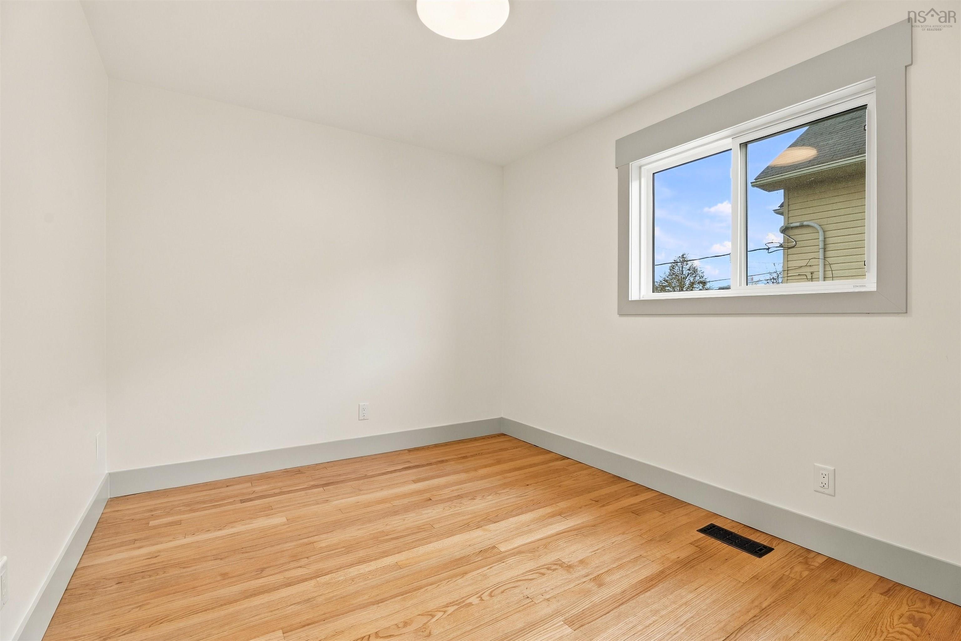 74 1/2 Belle Vista Drive, Dartmouth, NS (MLS® 202625912) — Neutral-toned interior featuring wood-finish flooring, a sliding window with wide gray casing, and a ceiling-mounted light fixture