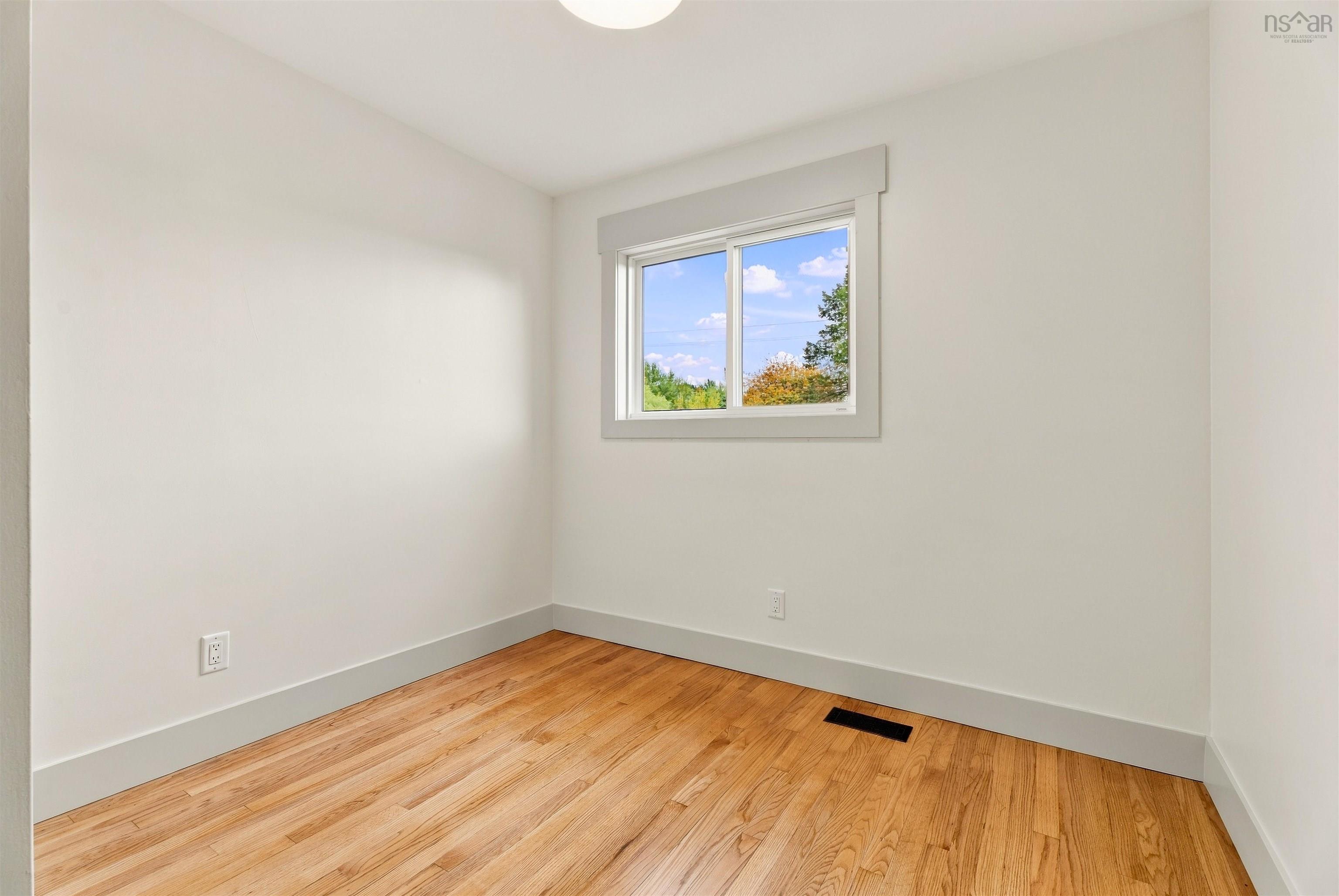 74 1/2 Belle Vista Drive, Dartmouth, NS (MLS® 202625912) — Neutral-toned interior featuring wood-finish flooring, a sliding window with wide trim, and a ceiling-mounted light fixture