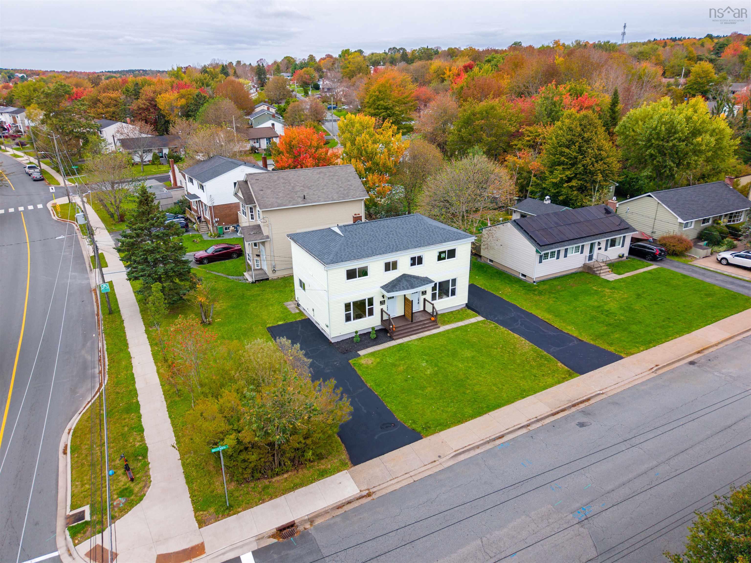 74 1/2 Belle Vista Drive, Dartmouth, NS (MLS® 202625912) — Two-story residence featuring a light-colored exterior, asphalt shingle roof, dual front entryways with wooden stairs, and a paved driveway on a corner lot