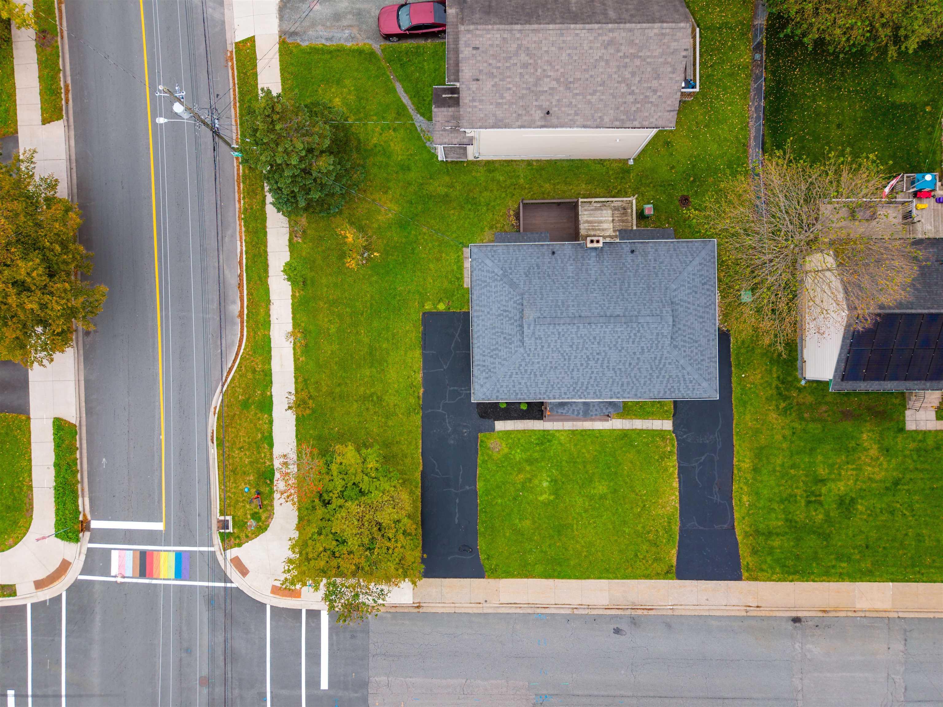 74 1/2 Belle Vista Drive, Dartmouth, NS (MLS® 202625912) — Aerial perspective of the lot featuring a shingled roof, asphalt driveway, and expansive lawn