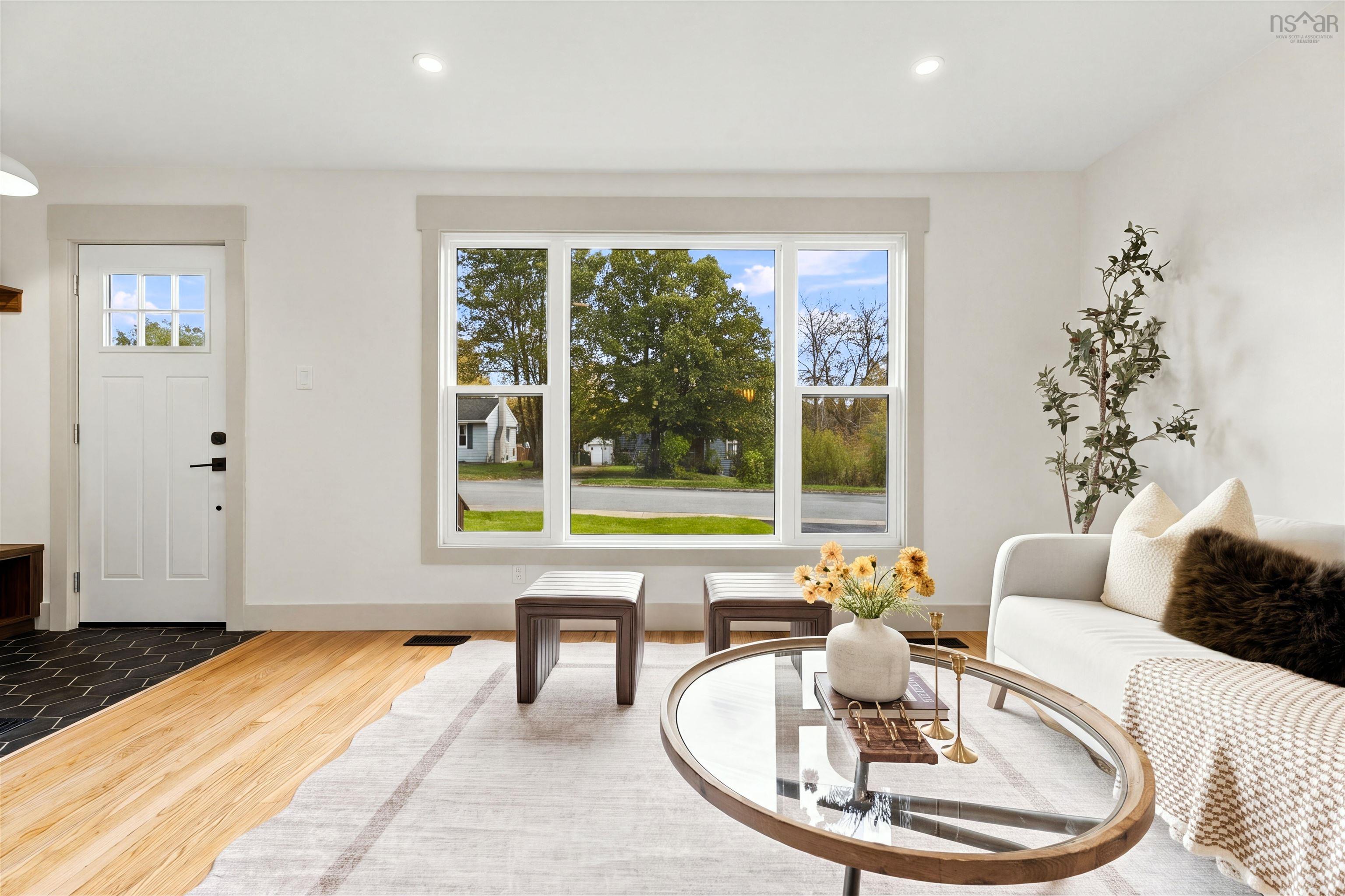 74 1/2 Belle Vista Drive, Dartmouth, NS (MLS® 202625912) — Living area featuring wood-finish flooring, a large picture window, recessed lighting, and a white exterior door with glass insert