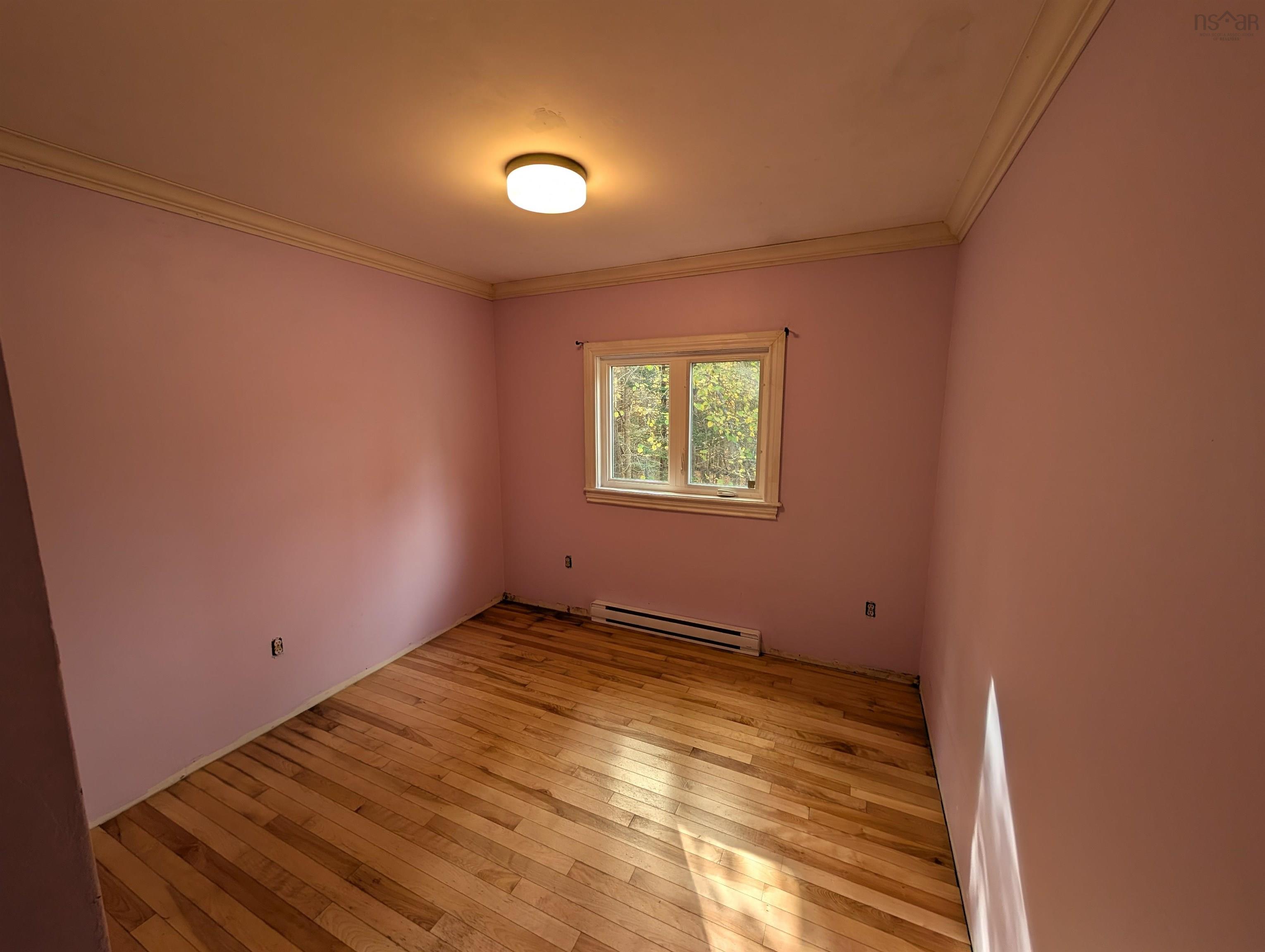 19 Foster Avenue, Fall River, NS (MLS® 202625937) — Room featuring wood-finish flooring, crown molding, a central flush-mount ceiling light, and a window with trim