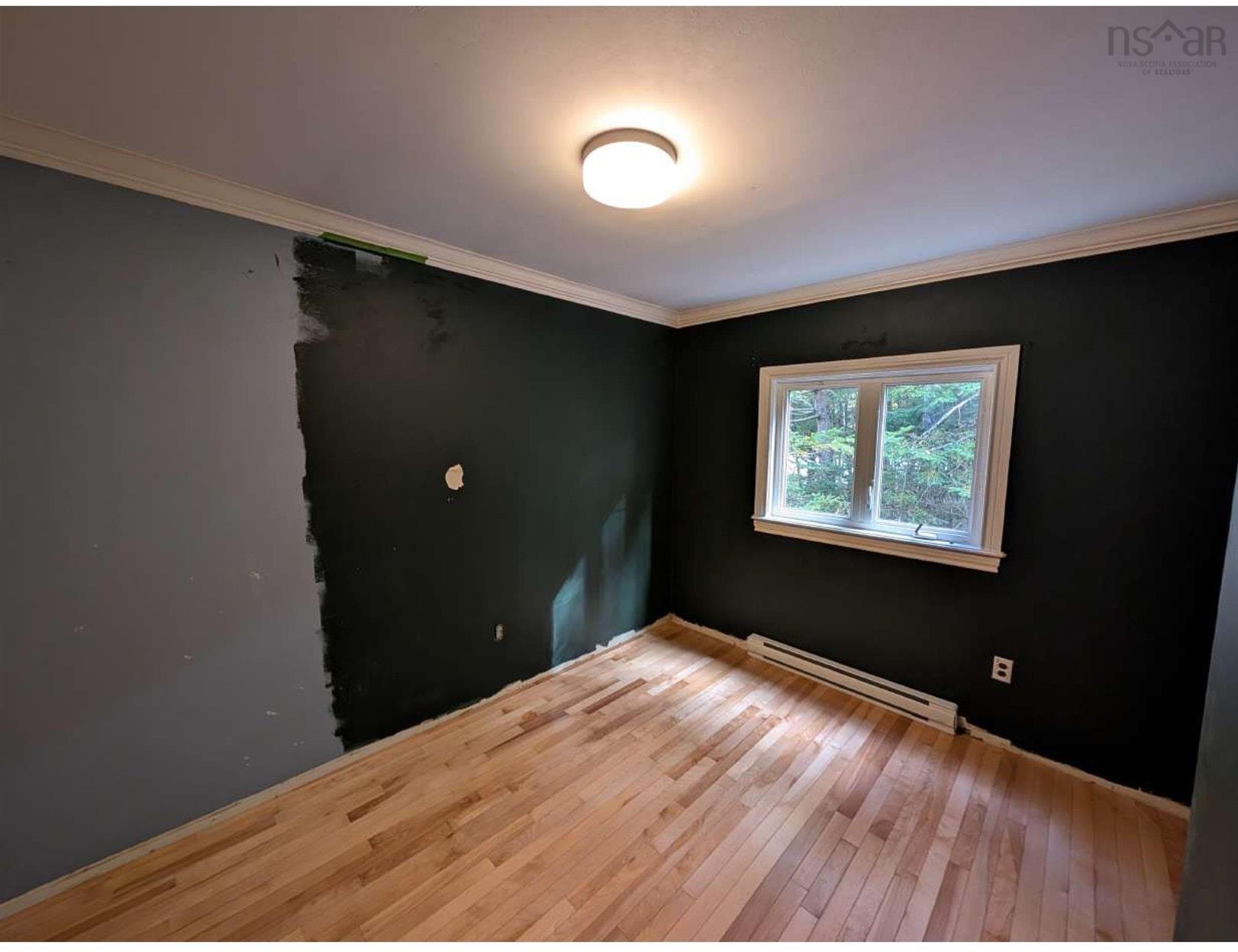 19 Foster Avenue, Fall River, NS (MLS® 202625937) — Room featuring wood-finish flooring, crown molding, a central ceiling-mounted light fixture, and a white-trimmed window