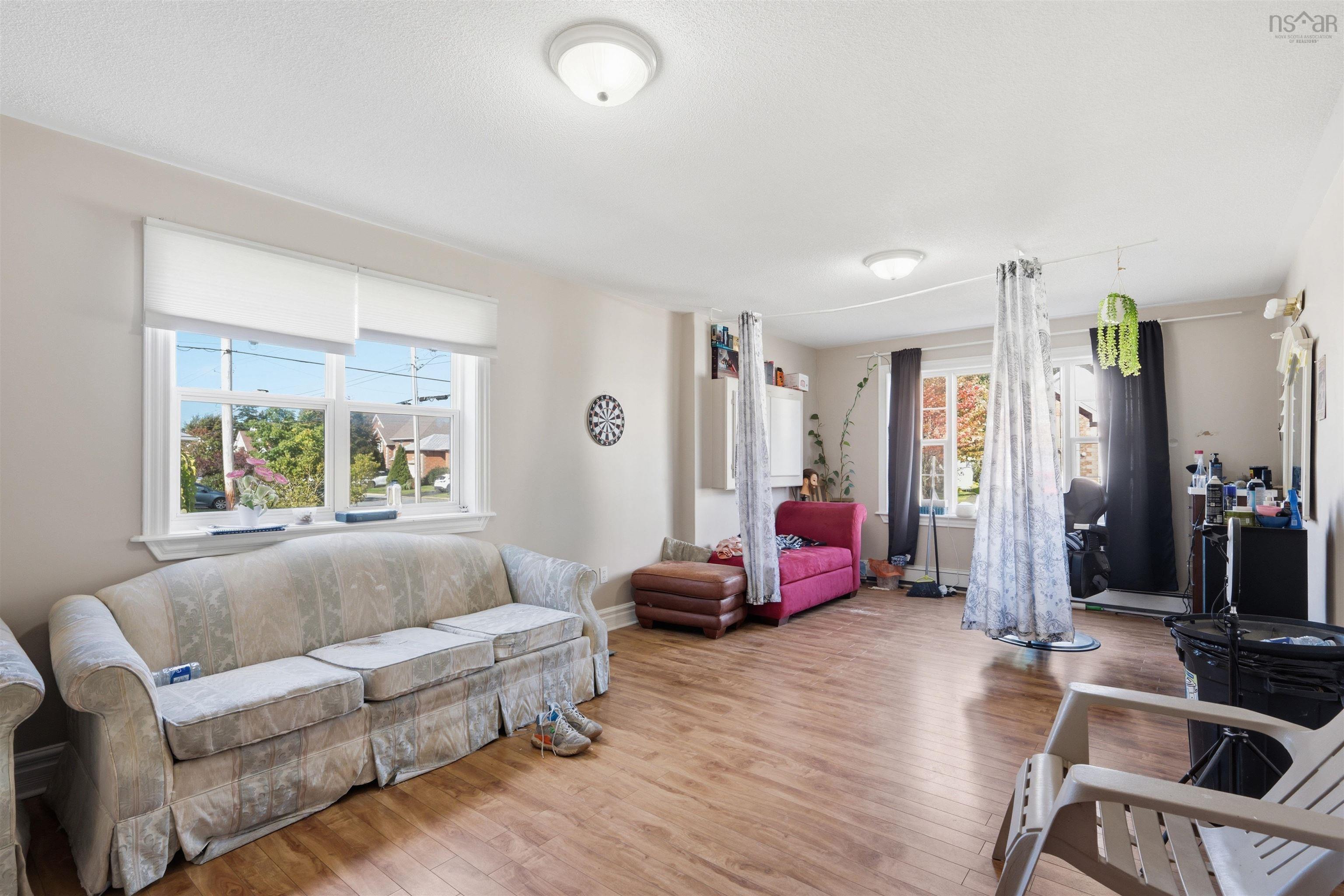 34 Lancaster Drive, Clayton Park, NS (MLS® 202626151) — Living area featuring wood-finish flooring, dual flush-mount ceiling fixtures, and multiple large windows