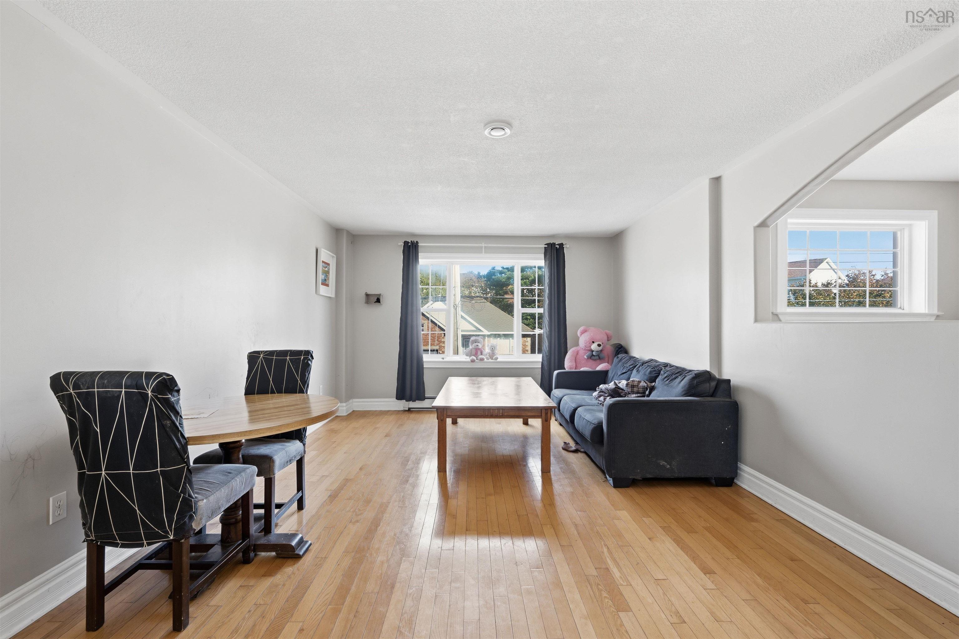 34 Lancaster Drive, Clayton Park, NS (MLS® 202626151) — Open-concept living space featuring wood-finish flooring, a large picture window, and a recessed wall opening