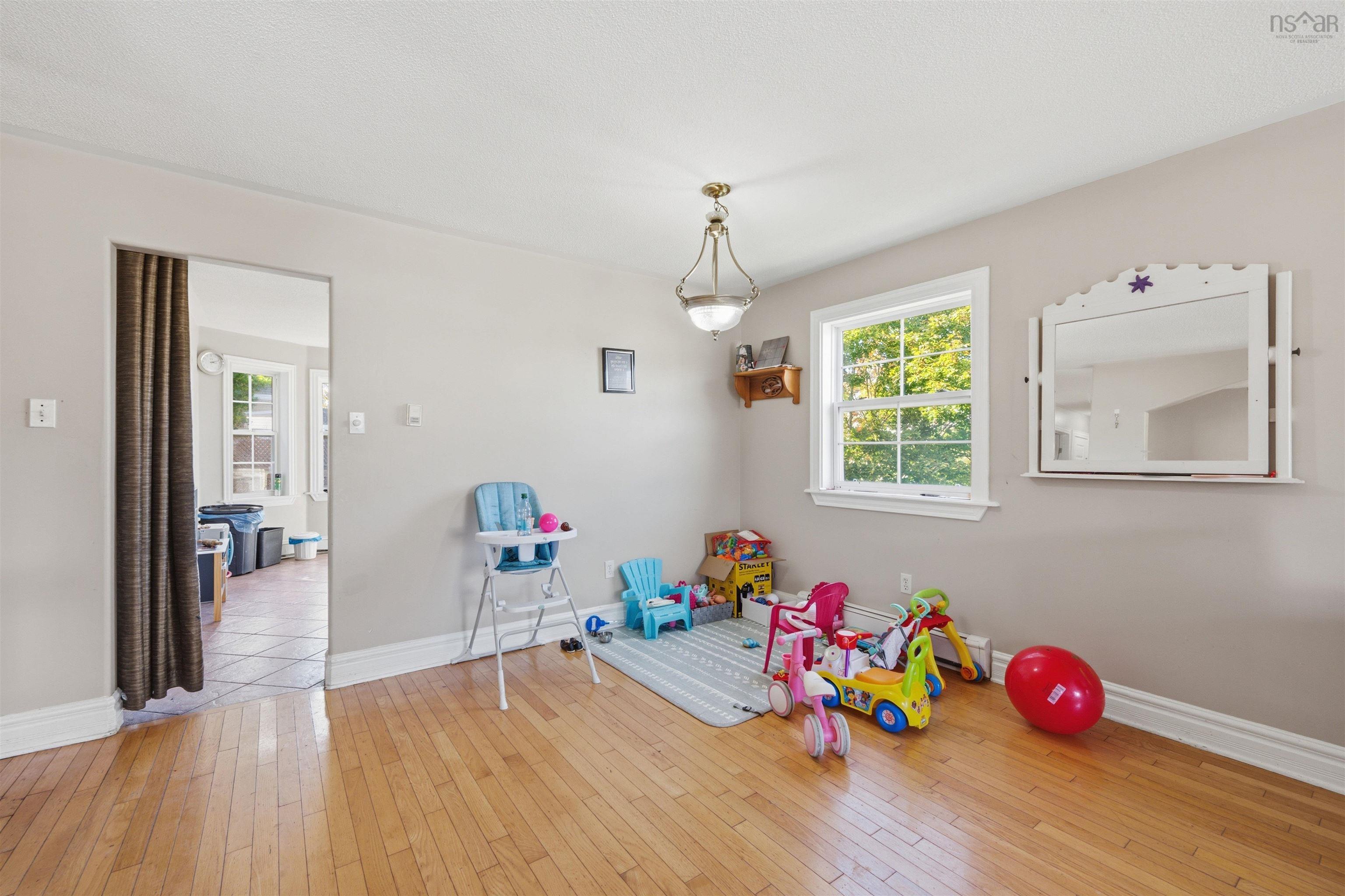 34 Lancaster Drive, Clayton Park, NS (MLS® 202626151) — Interior space featuring wood-finish flooring, a multi-pane window with exterior greenery, and a pendant light fixture