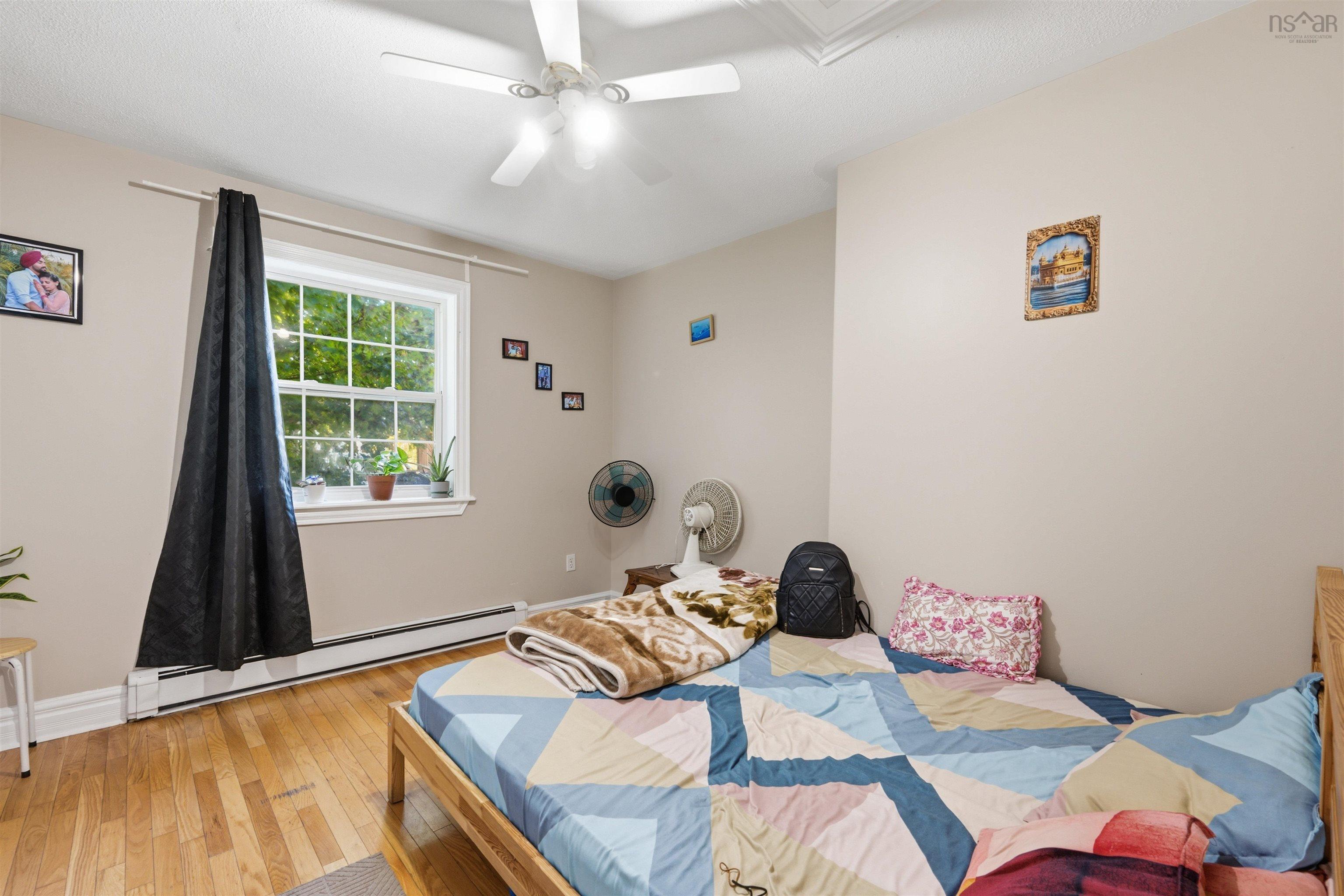 34 Lancaster Drive, Clayton Park, NS (MLS® 202626151) — Room featuring wood-finish flooring, a multi-pane window with a deep sill, and a central ceiling fan with an integrated light fixture