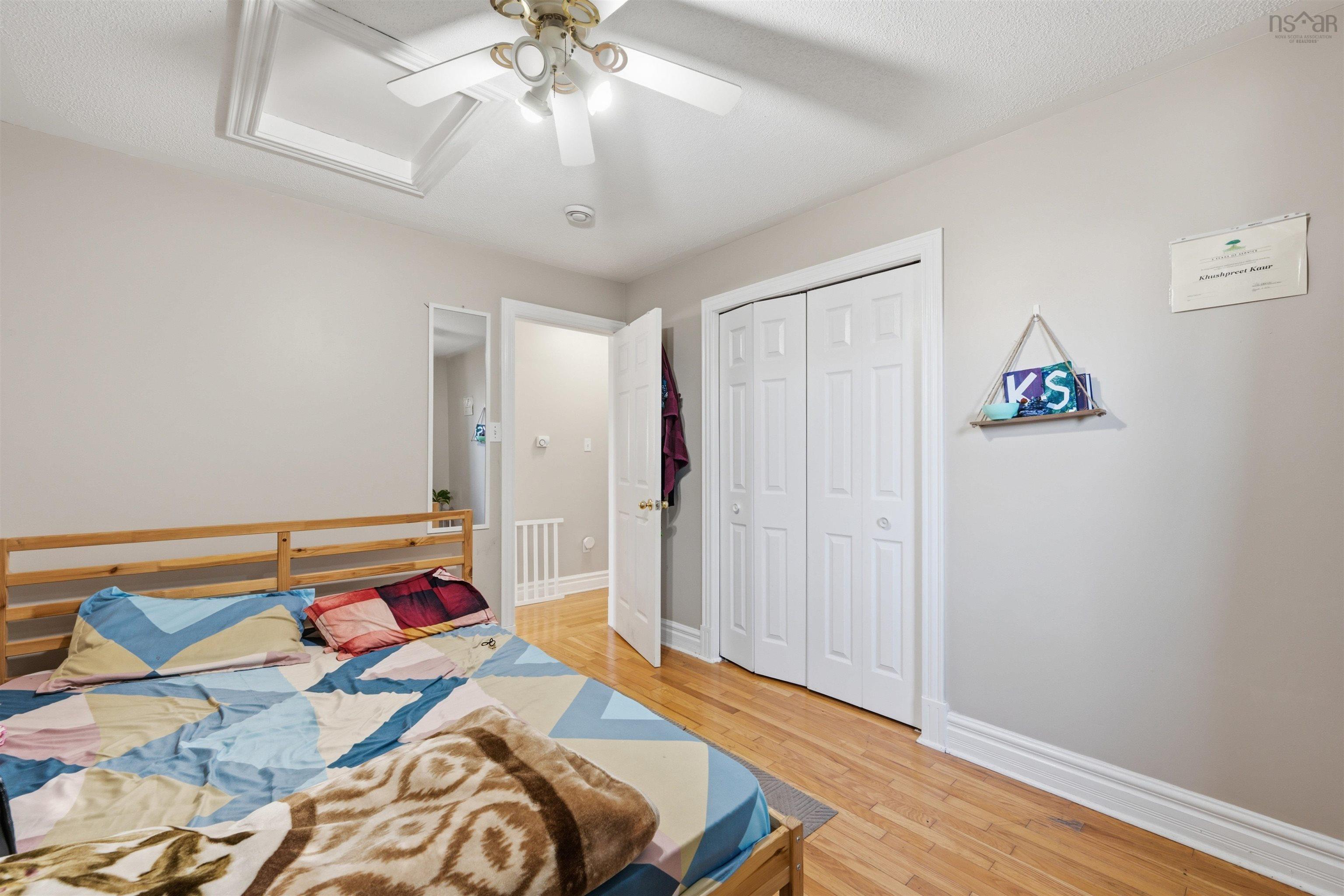 34 Lancaster Drive, Clayton Park, NS (MLS® 202626151) — Room featuring wood-finish flooring, a white ceiling fan with integrated lighting, and a closet with bifold doors