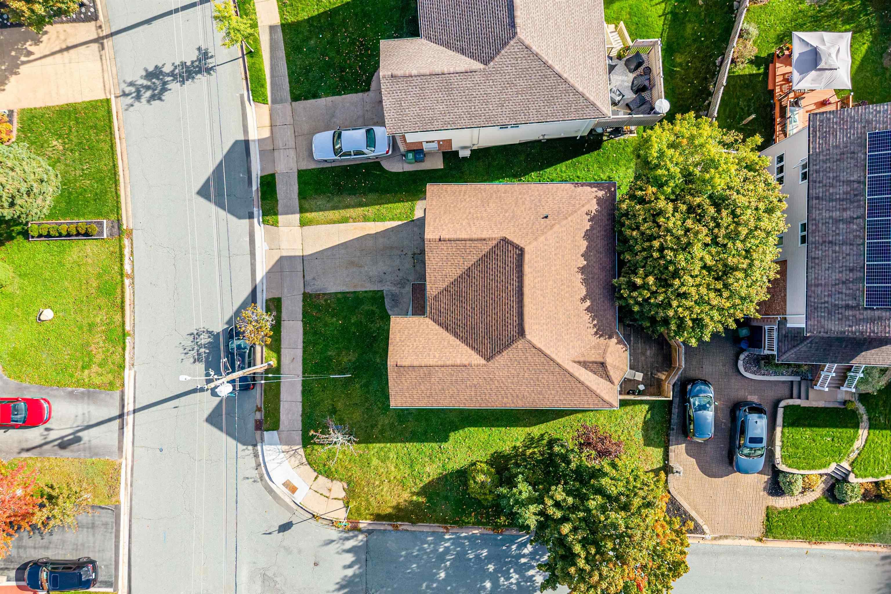 34 Lancaster Drive, Clayton Park, NS (MLS® 202626151) — Aerial perspective of property featuring a multi-pitched shingled roof, paved driveway, and grass-covered grounds with mature trees