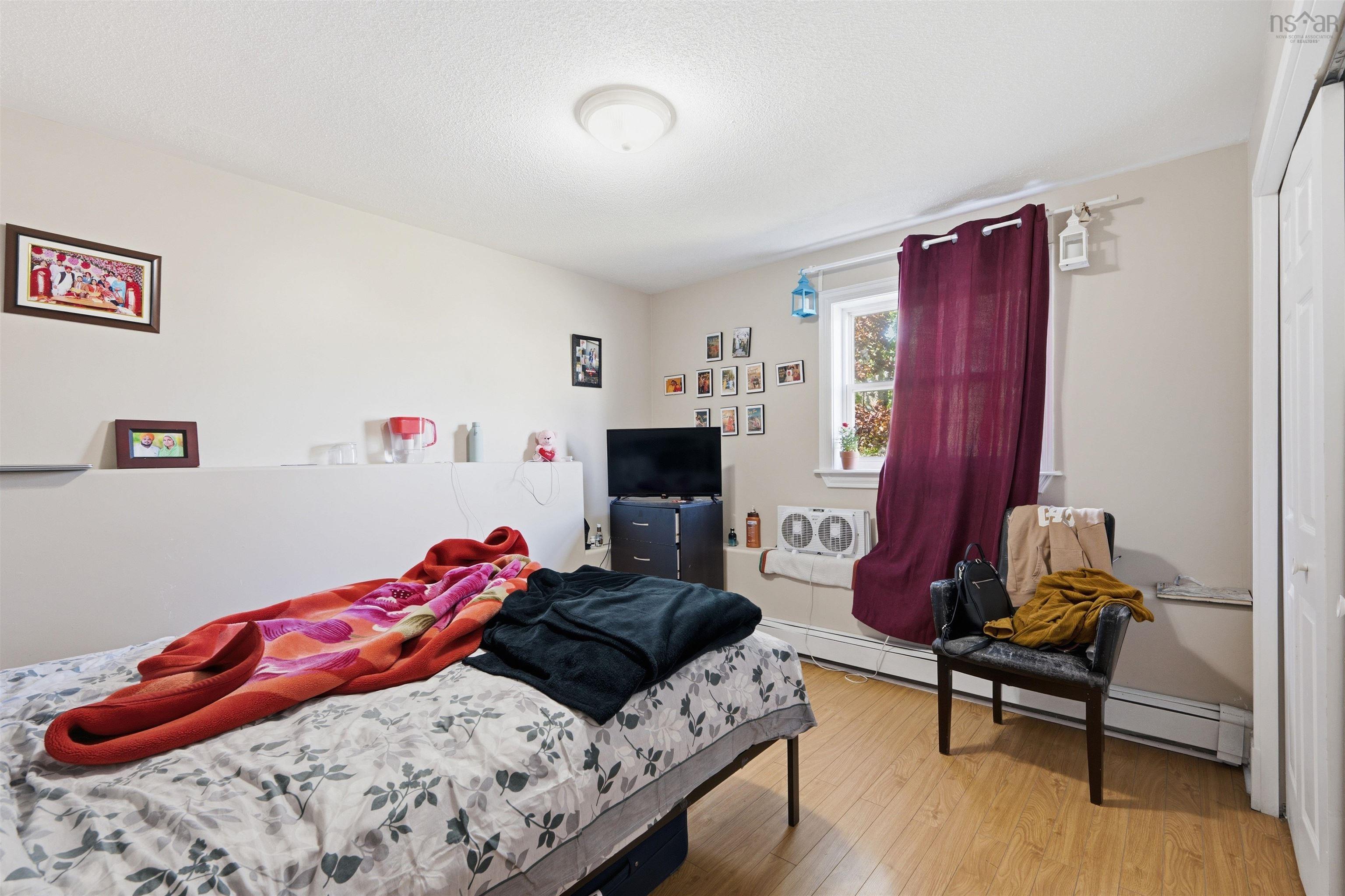 34 Lancaster Drive, Clayton Park, NS (MLS® 202626151) — Room featuring wood-finish flooring, a single-hung window, a built-in architectural ledge, a ceiling-mounted light fixture, and a sliding-panel closet door