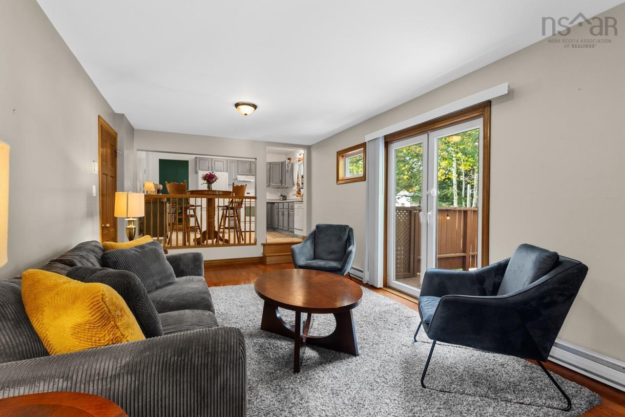 24 Rossi Drive, Dartmouth, NS (MLS® 202626410) — Living area featuring wood-finish flooring, glass-paneled double doors, and a wood railing partition