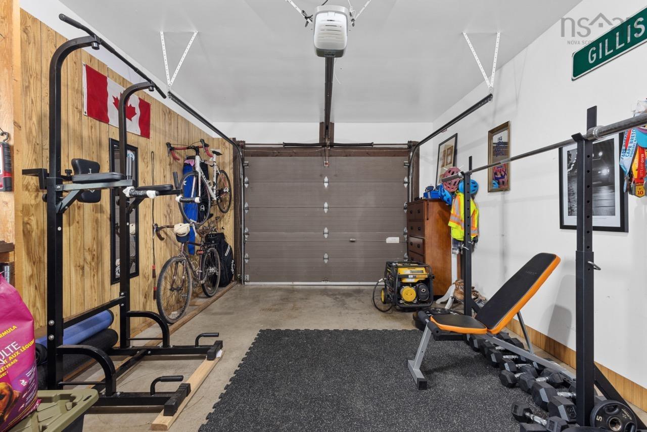 24 Rossi Drive, Dartmouth, NS (MLS® 202626410) — Attached garage featuring a wood-paneled wall, concrete flooring, and an automated garage door opener