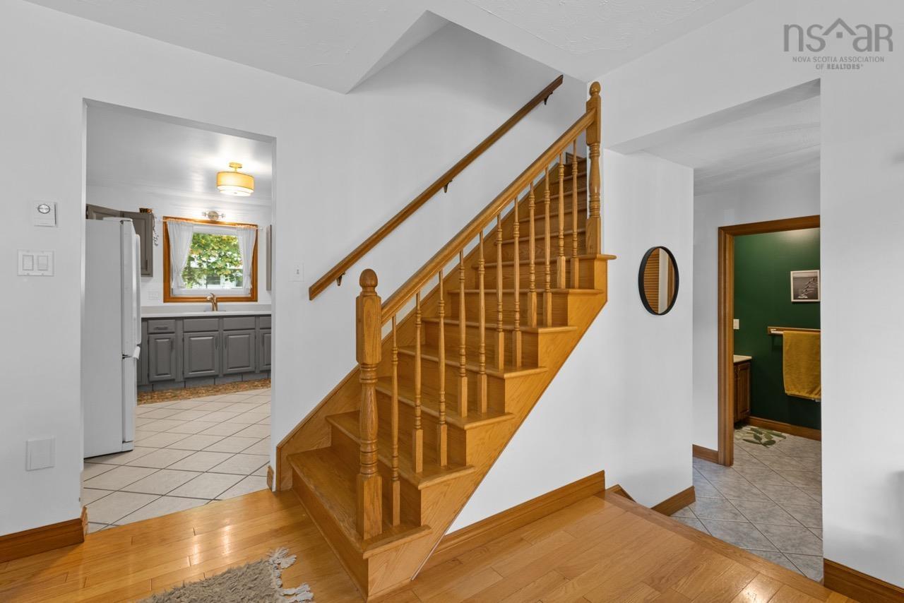 24 Rossi Drive, Dartmouth, NS (MLS® 202626410) — Open staircase featuring a wooden handrail and balusters, paired with wood-finish flooring