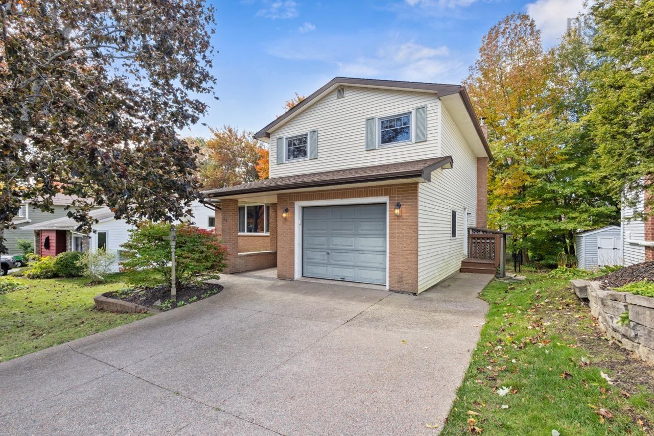 24 Rossi Drive, Dartmouth, NS (MLS® 202626410) — Two-story exterior featuring light-toned horizontal siding, a brick facade, a paved driveway, and an integrated single-car garage