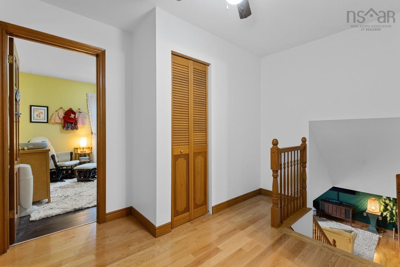 24 Rossi Drive, Dartmouth, NS (MLS® 202626410) — Wood-finish flooring, louvered bi-fold closet door, and natural wood staircase railing