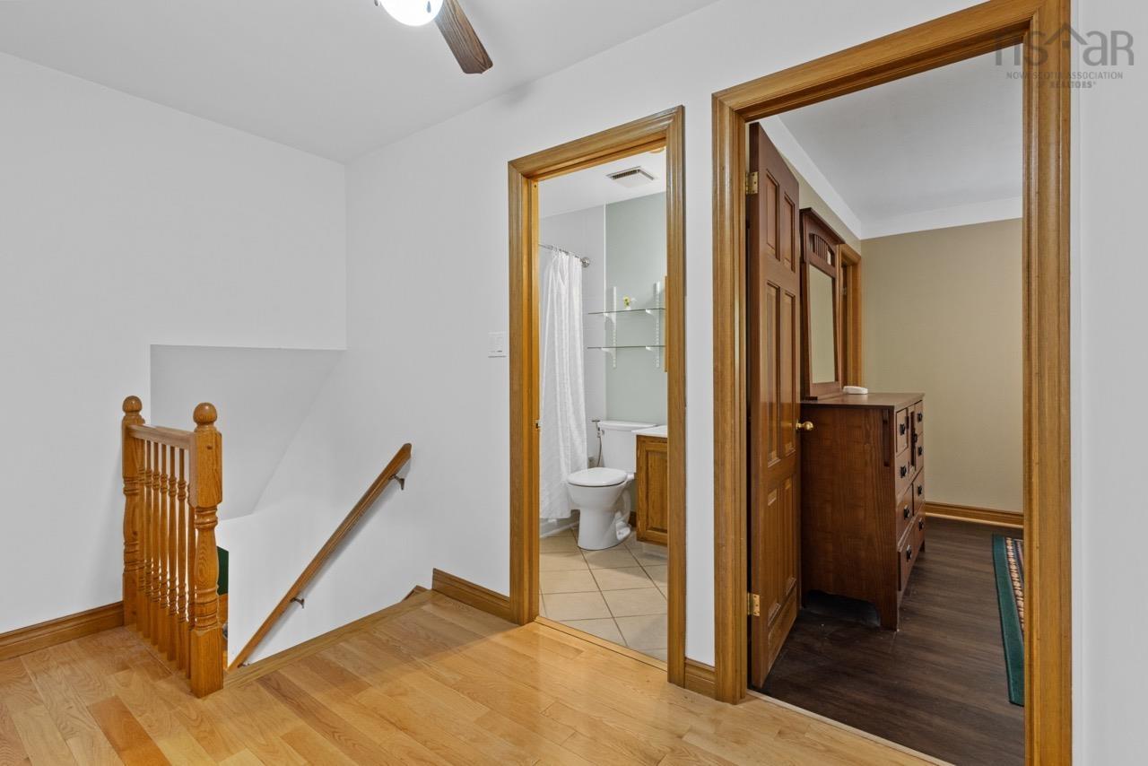 24 Rossi Drive, Dartmouth, NS (MLS® 202626410) — Hardwood flooring, natural wood trim, staircase with a wooden balustrade, and doorways featuring paneled wood doors