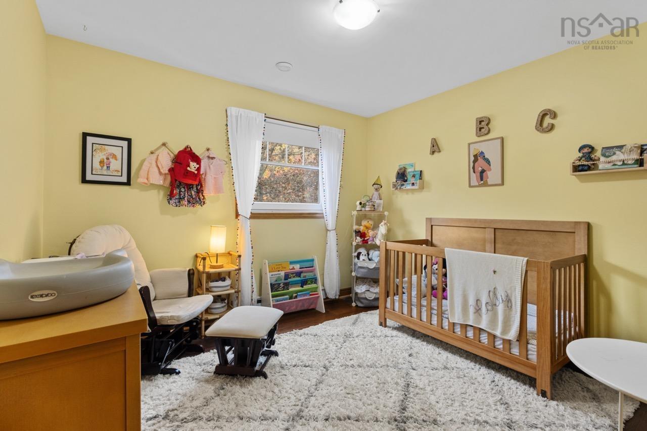 24 Rossi Drive, Dartmouth, NS (MLS® 202626410) — Bedroom featuring wood-finish flooring, a multi-pane window with wood trim, and a ceiling-mounted light fixture
