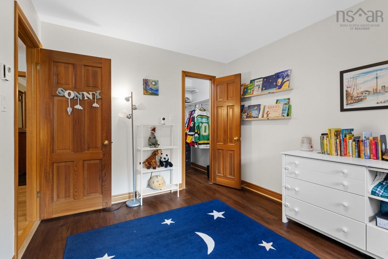 24 Rossi Drive, Dartmouth, NS (MLS® 202626410) — Interior space featuring wood-finish flooring, two six-panel natural wood doors, and a walk-in closet with built-in shelving