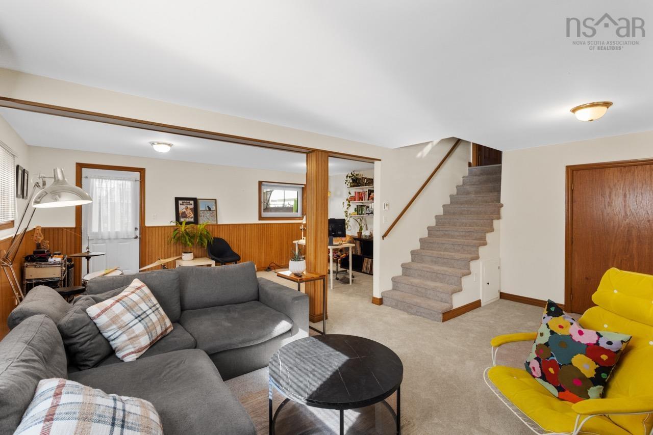 24 Rossi Drive, Dartmouth, NS (MLS® 202626410) — Multi-purpose area featuring wood wainscoting, carpeted flooring, a staircase with a wooden handrail, and a door providing exterior access
